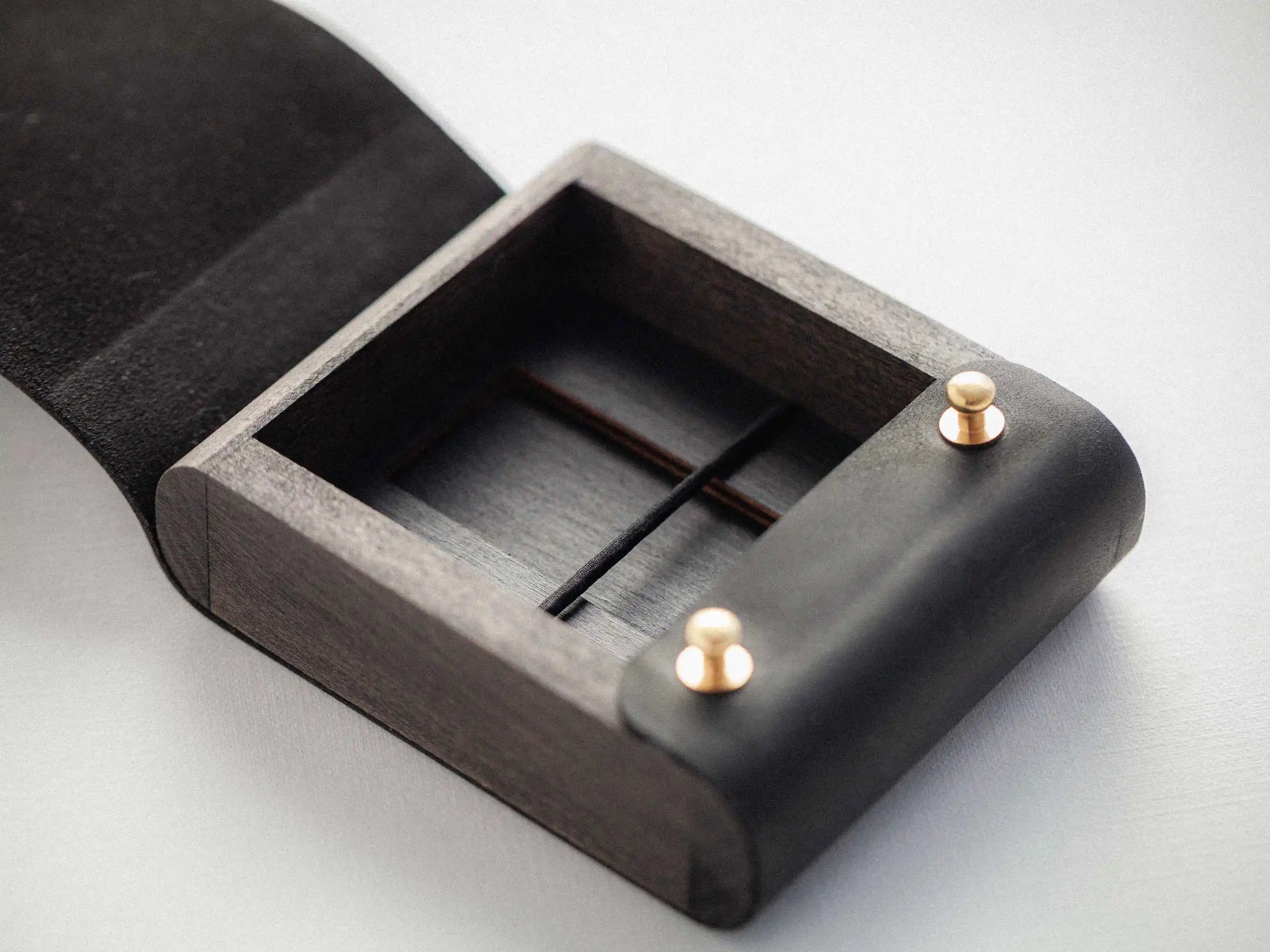 Open black leather USB presentation box showing inner compartment and elastic holder