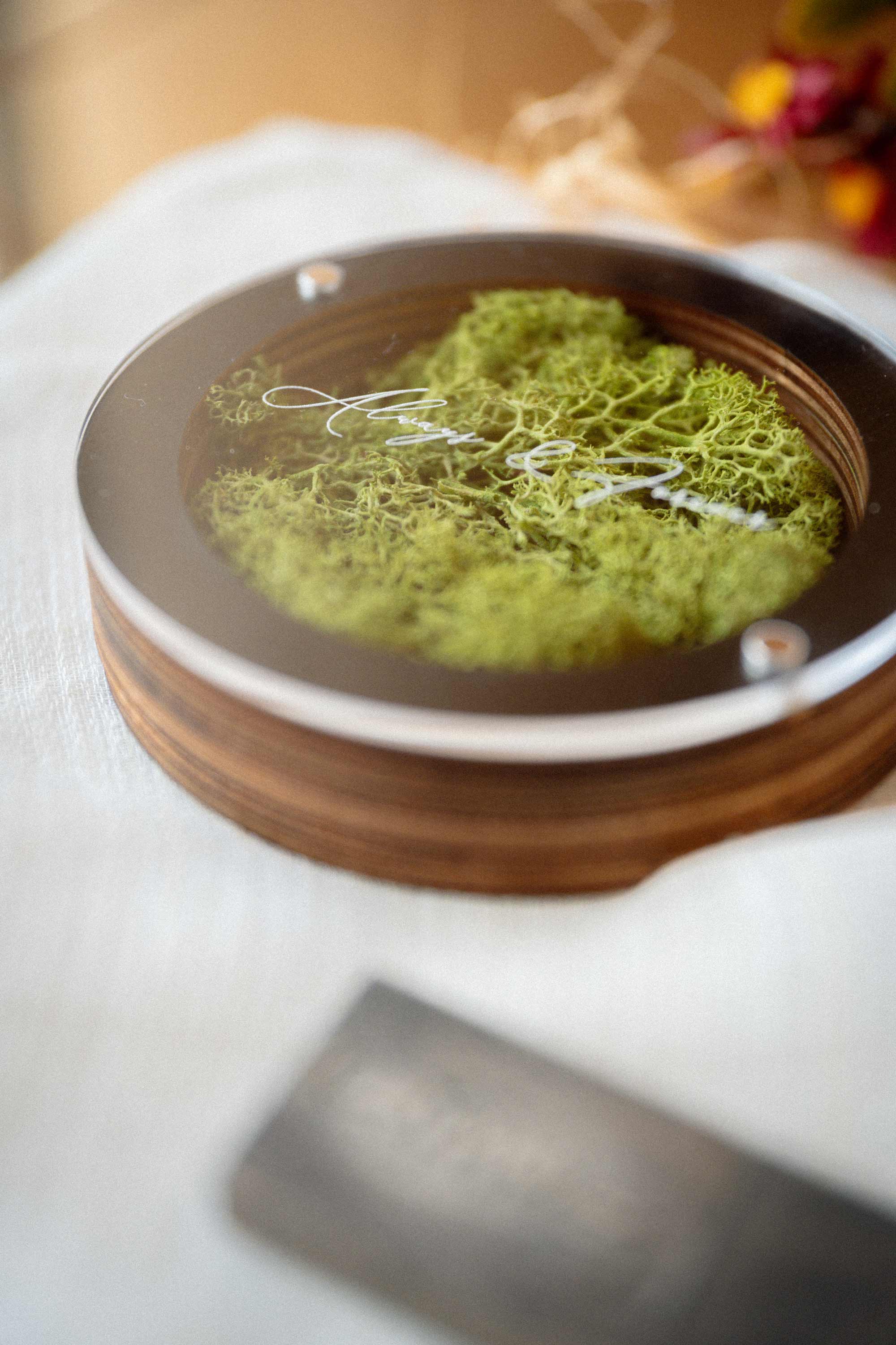 Black round USB box with stabilized green Scandinavian moss on a light surface
