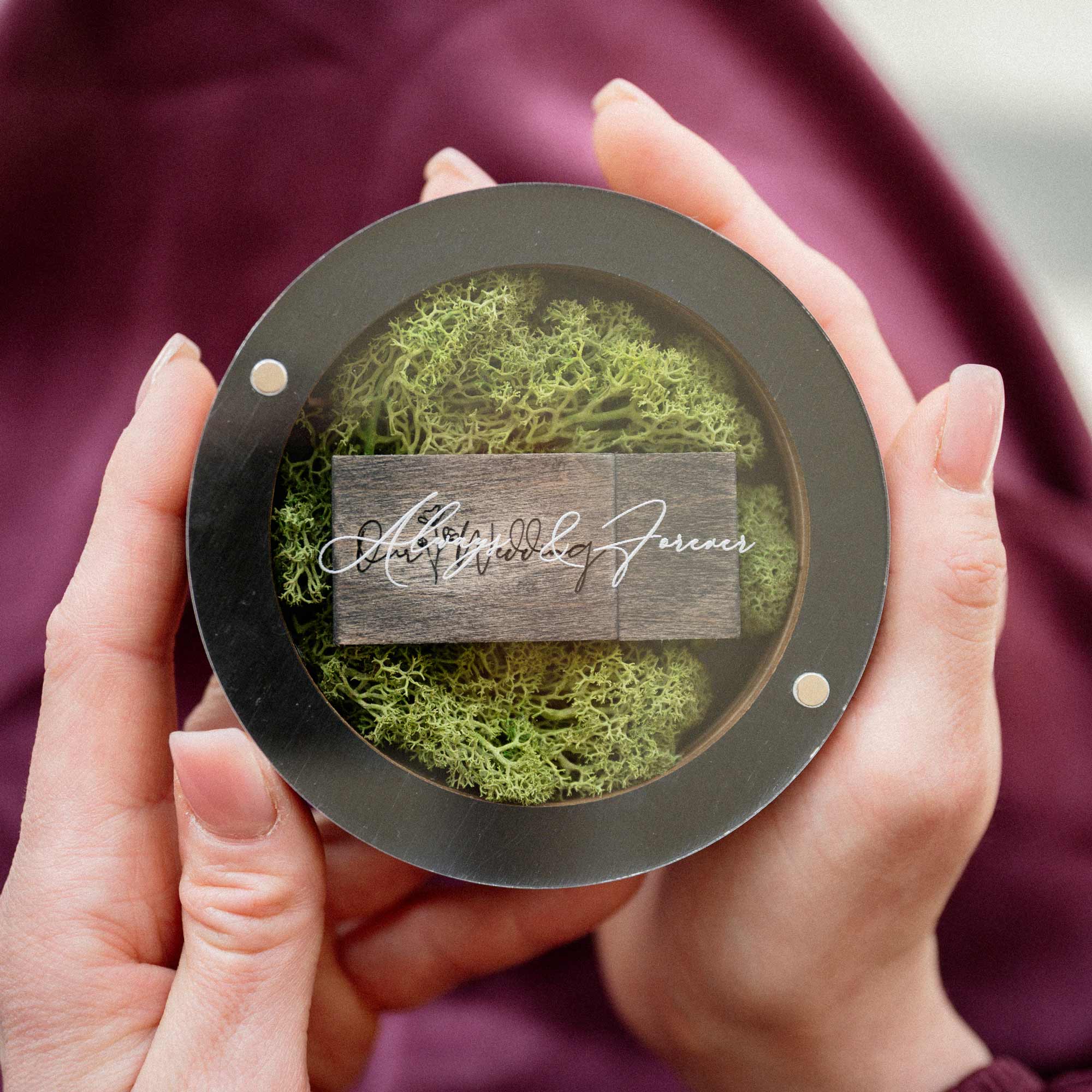 Black USB box with wooden flash drive shown in hands for size