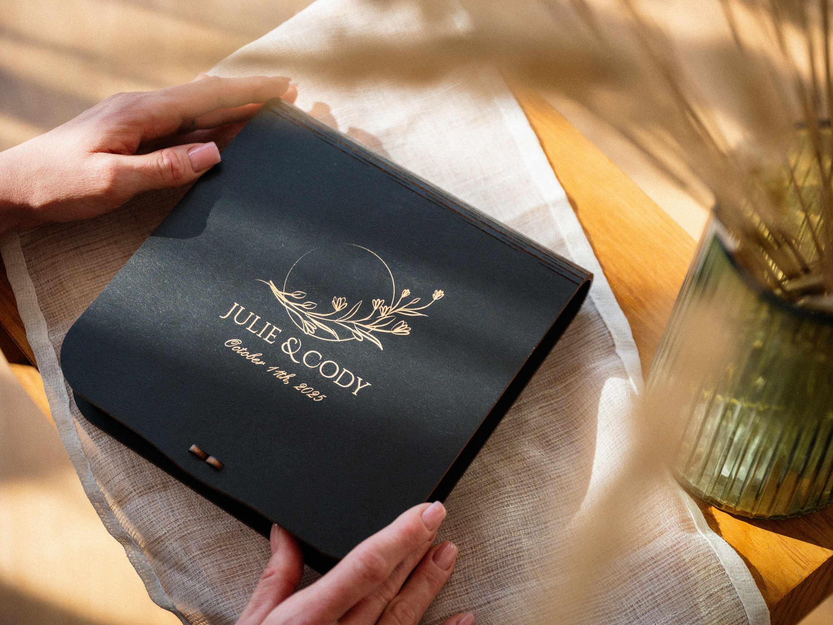 Hands holding closed black personalized keepsake photo box for wedding prints