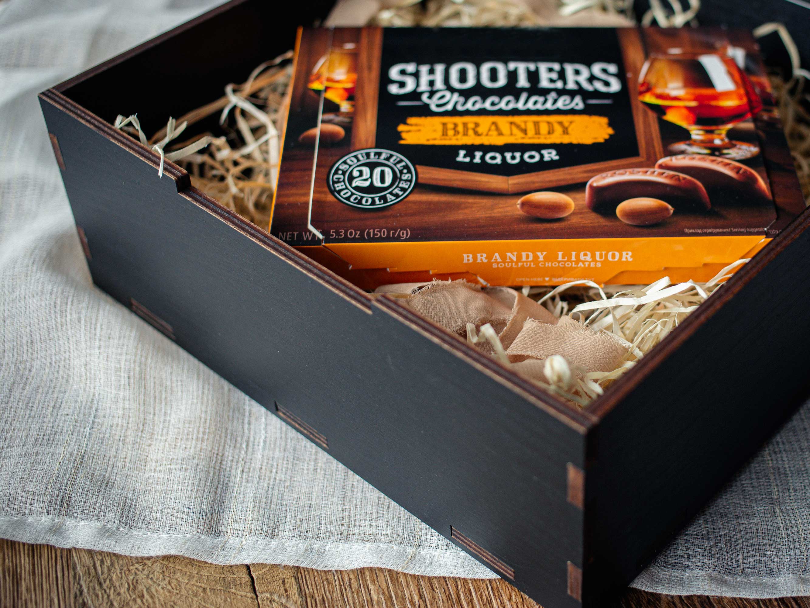 Personalized black gift box with acrylic lid styled with chocolates and filler, gift presentation example, contents not included