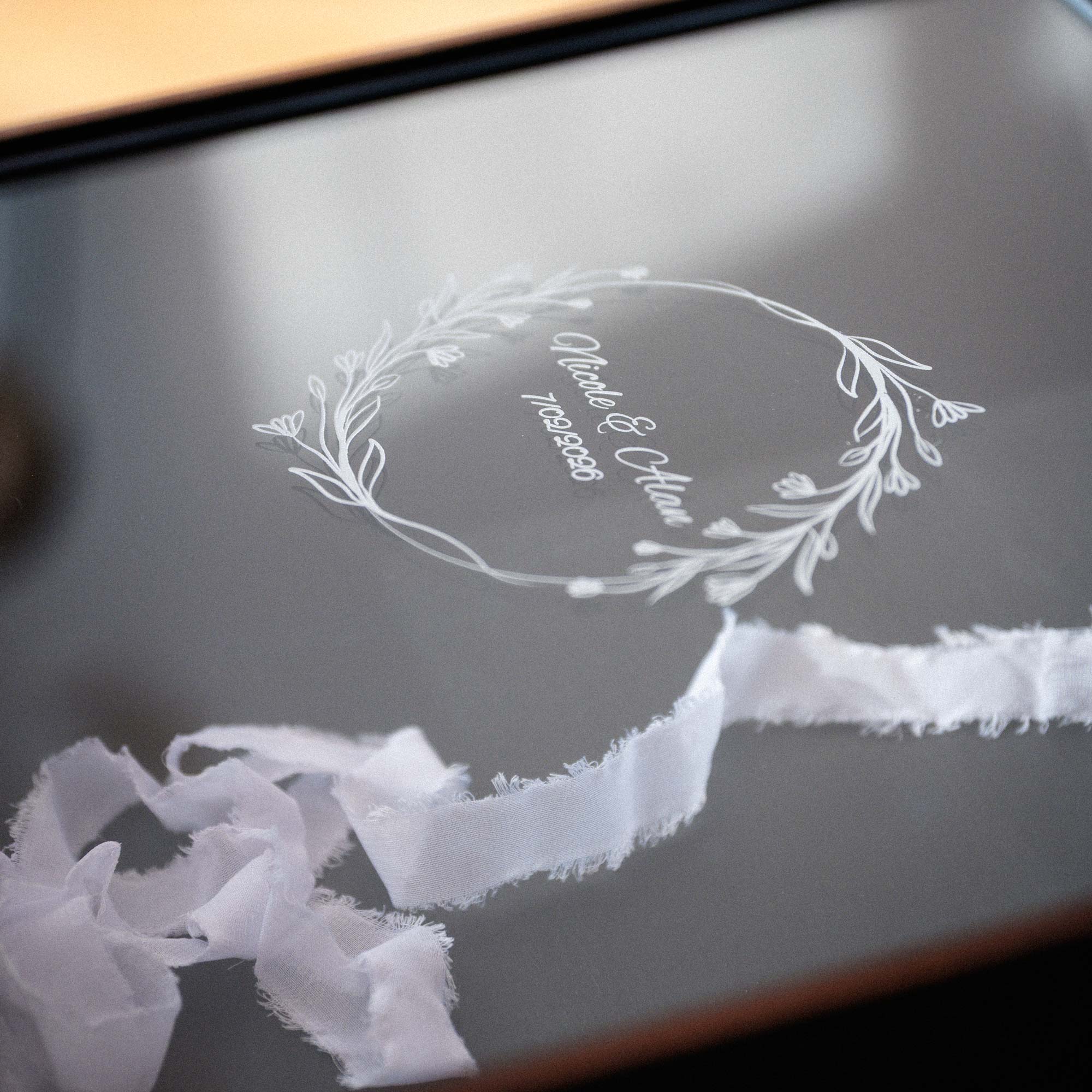 Close-up of personalized acrylic lid on black wooden keepsake box with custom engraving for wedding gift or photo album