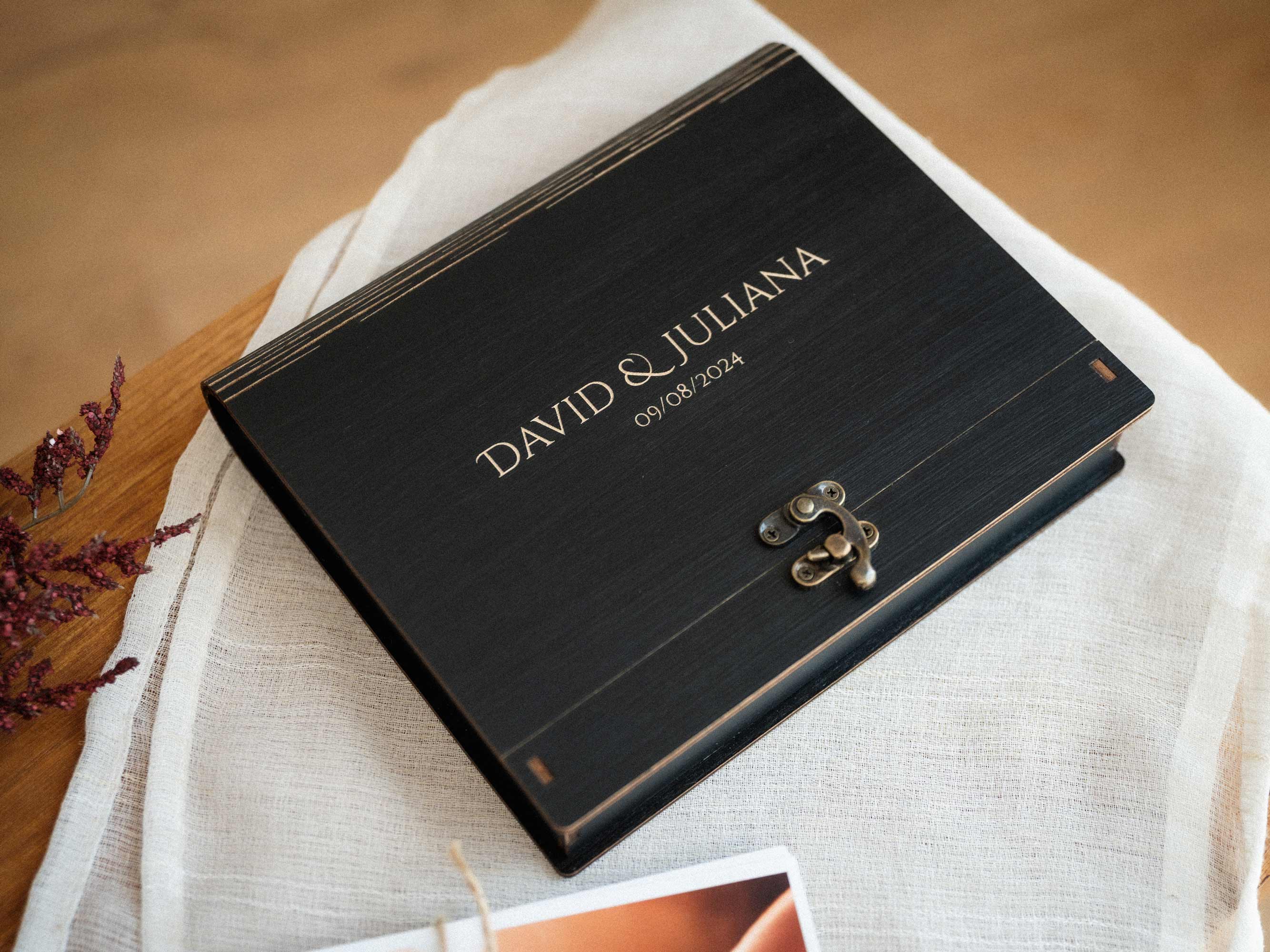 Black wedding photo box slightly open with printed photos inside