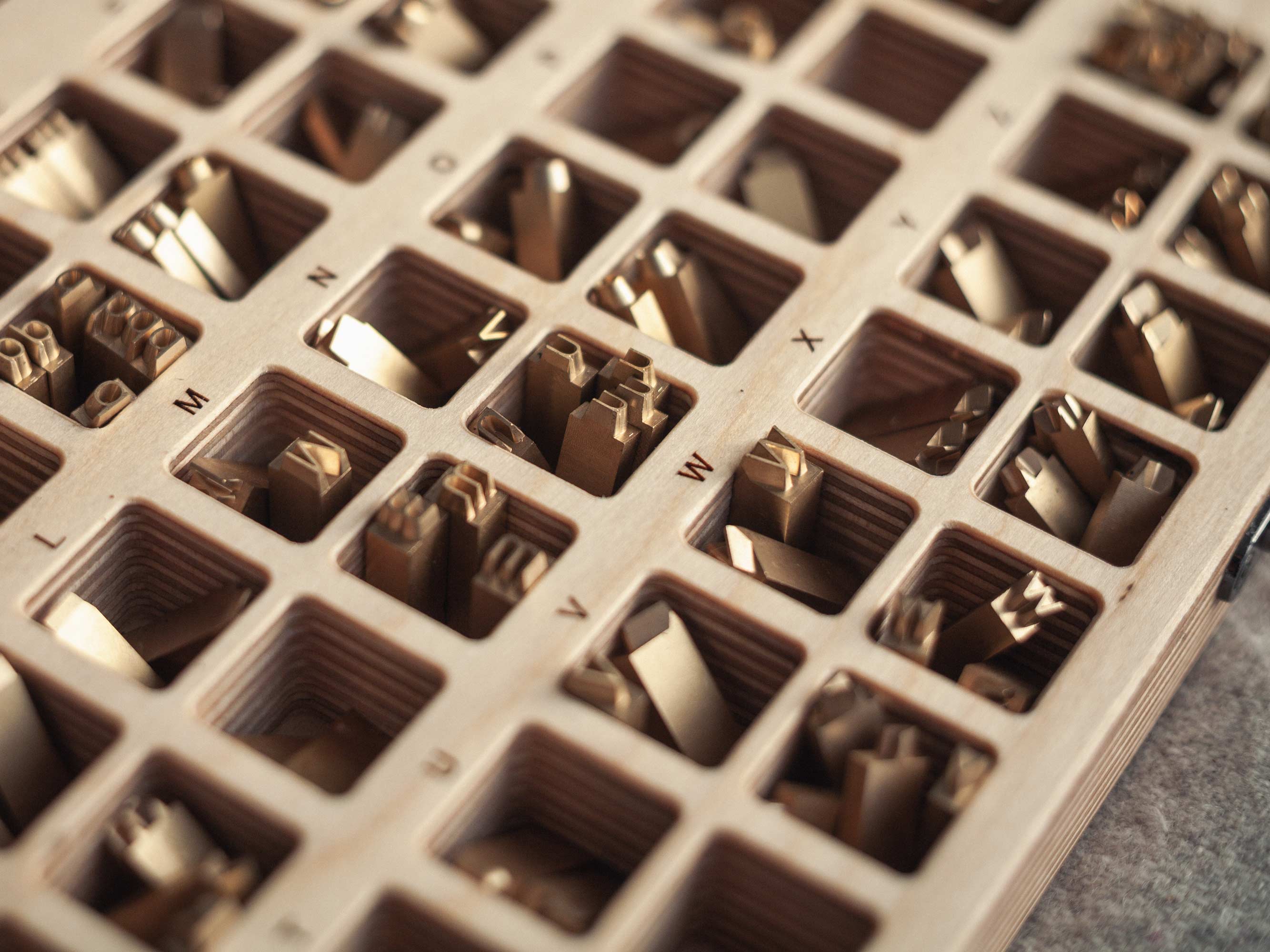 Open leather USB case with wooden flash drive inside, styled with dried grasses