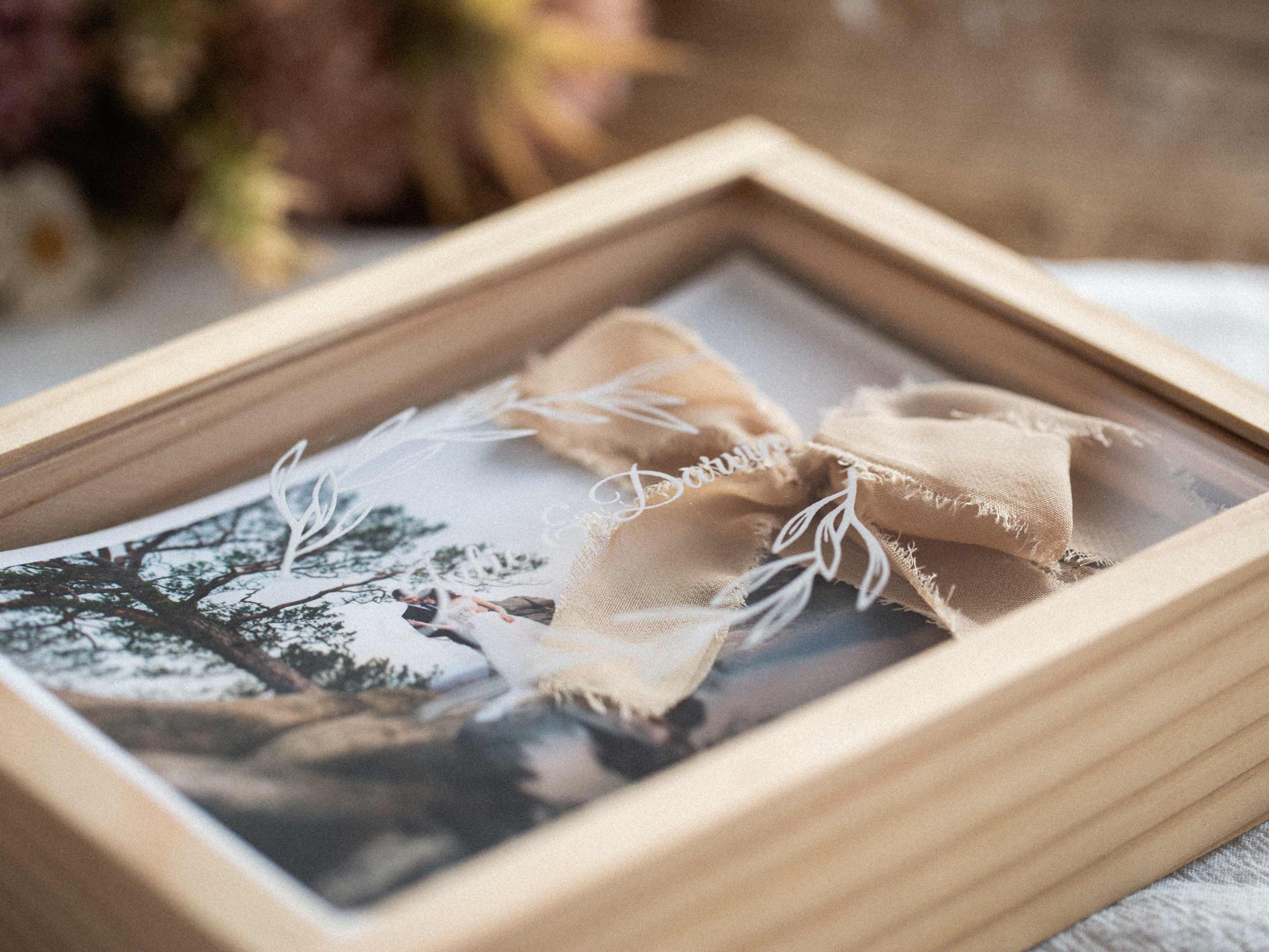 Maple wooden photo box closed with linen ribbon bow, lifestyle styling with dried flowers.