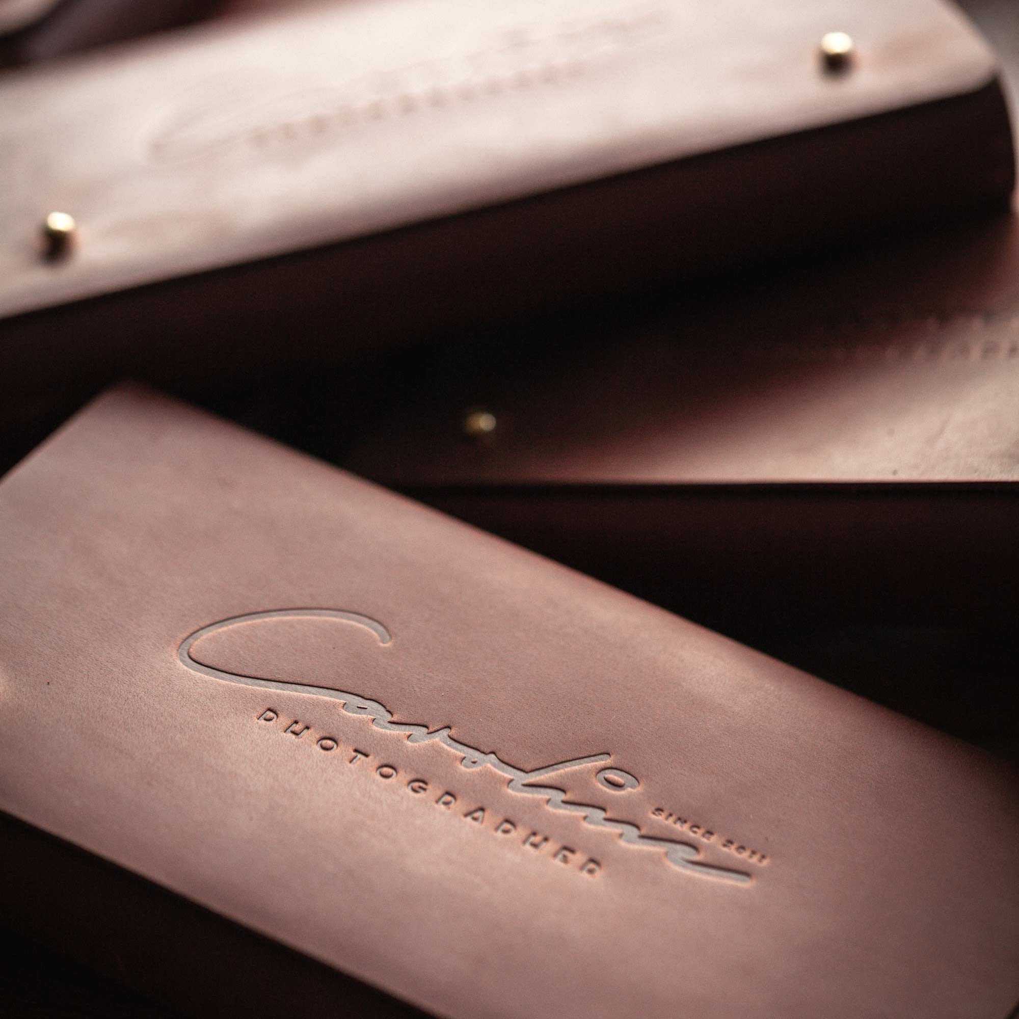 Detail of premium brown leather packaging with subtle hot-stamped studio logo.