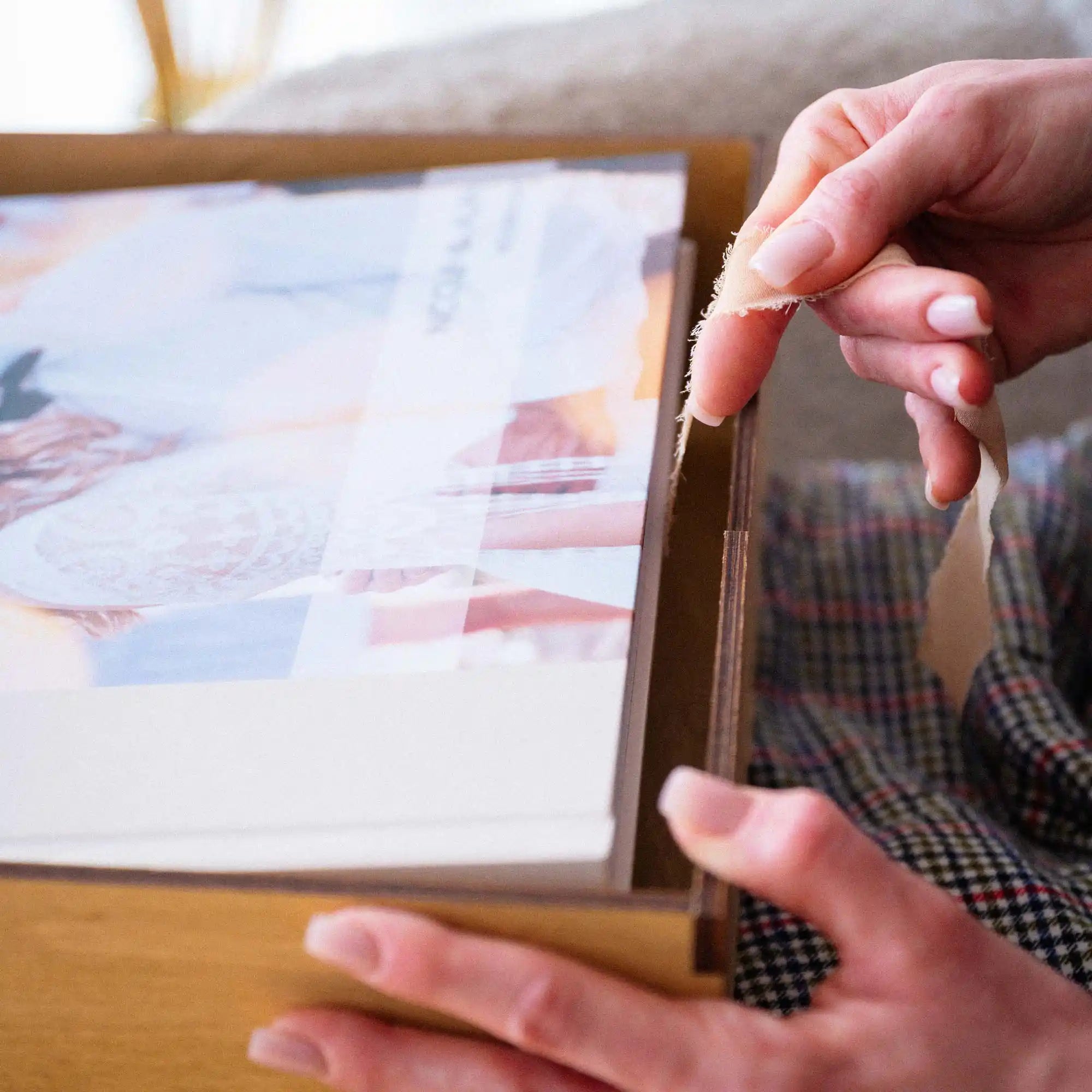 Close-up of hand opening the acrylic lid of a Gold Oak wedding album box