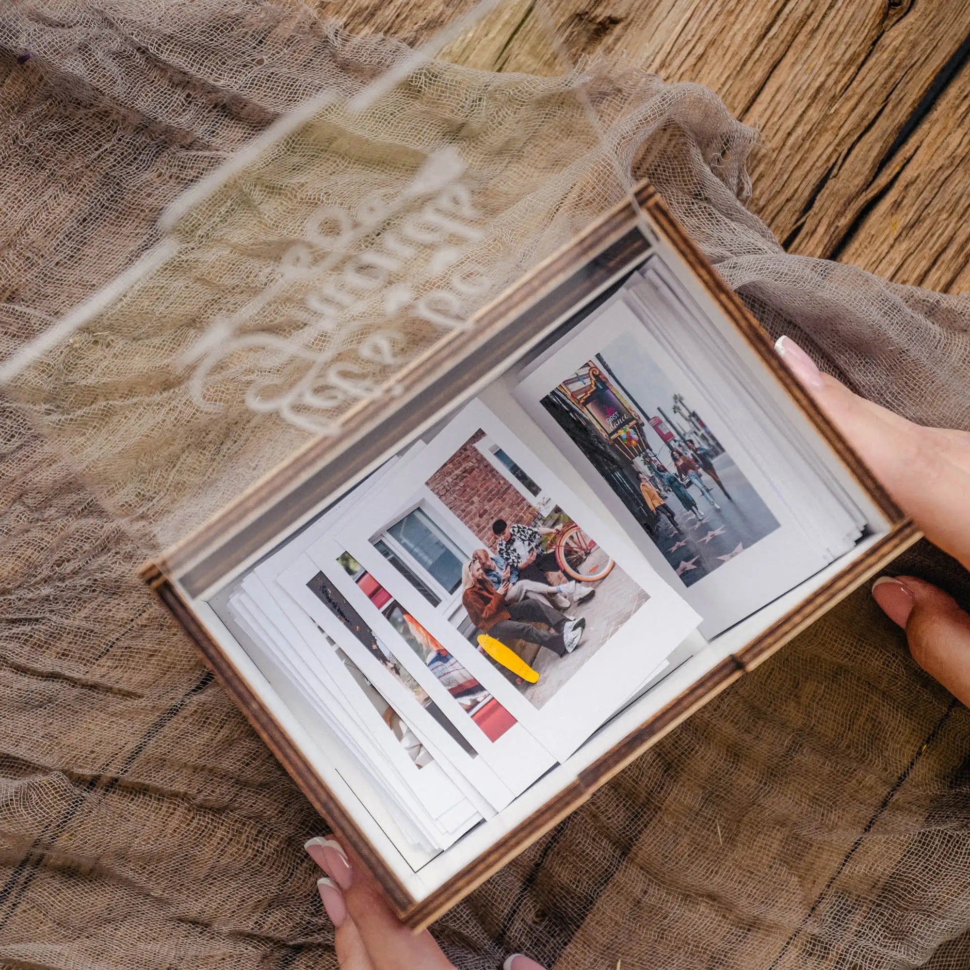 White Instax Mini photo box with acrylic lid and instant prints inside