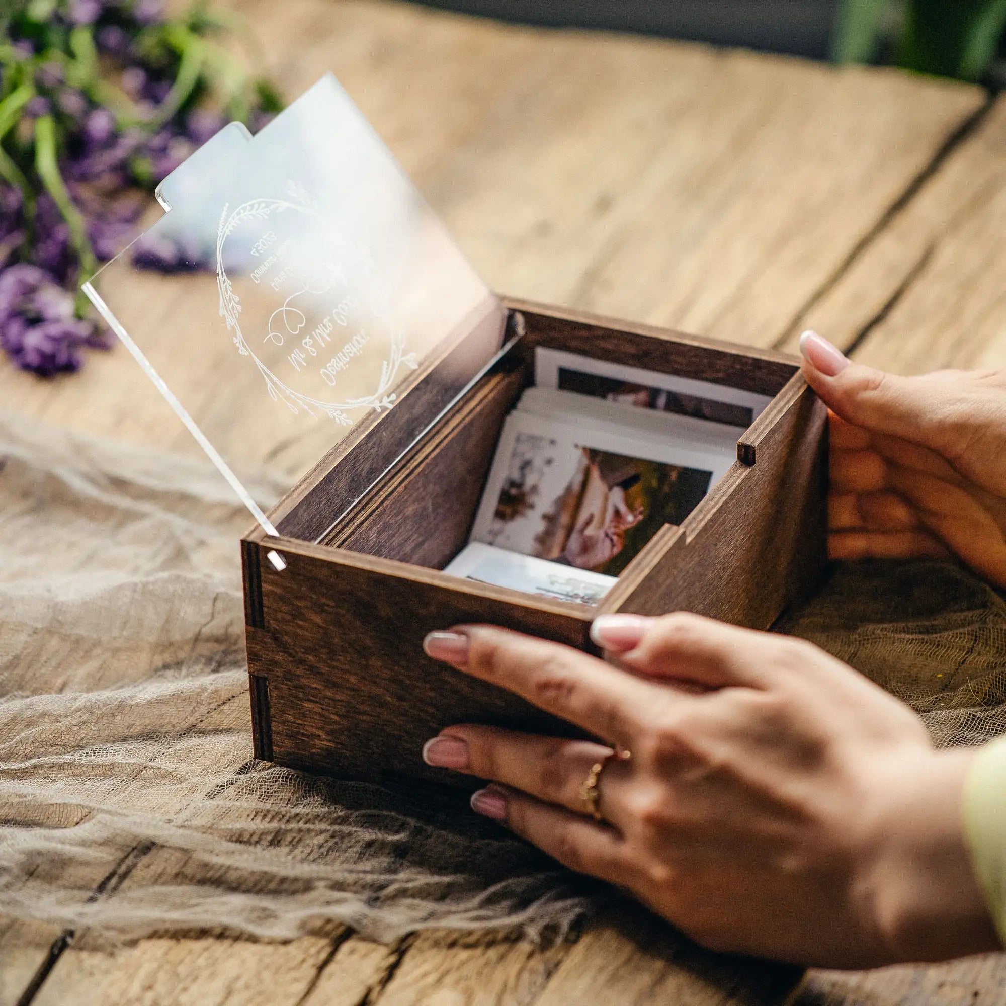 Hands opening a personalized wooden Instax Mini photo box