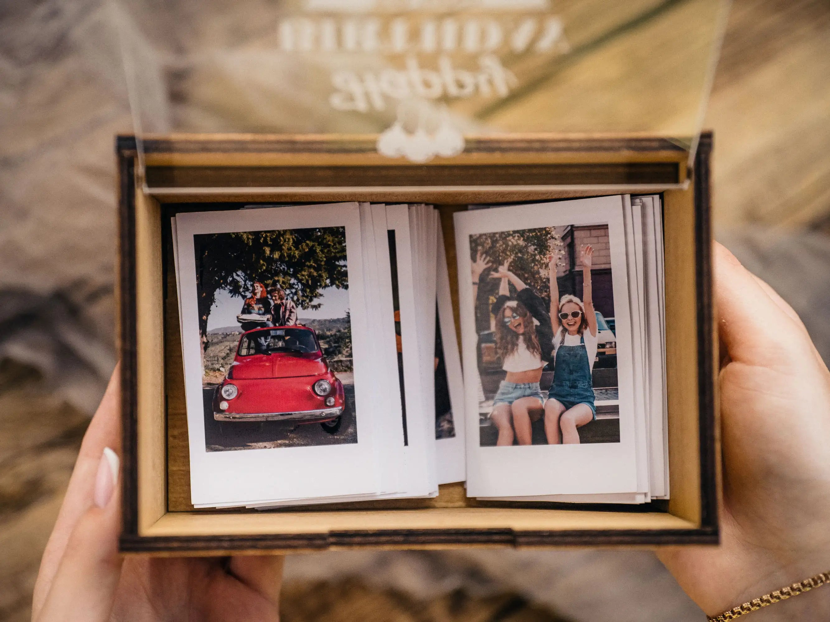 Open Golden Oak Instax Mini photo box showing instant prints inside