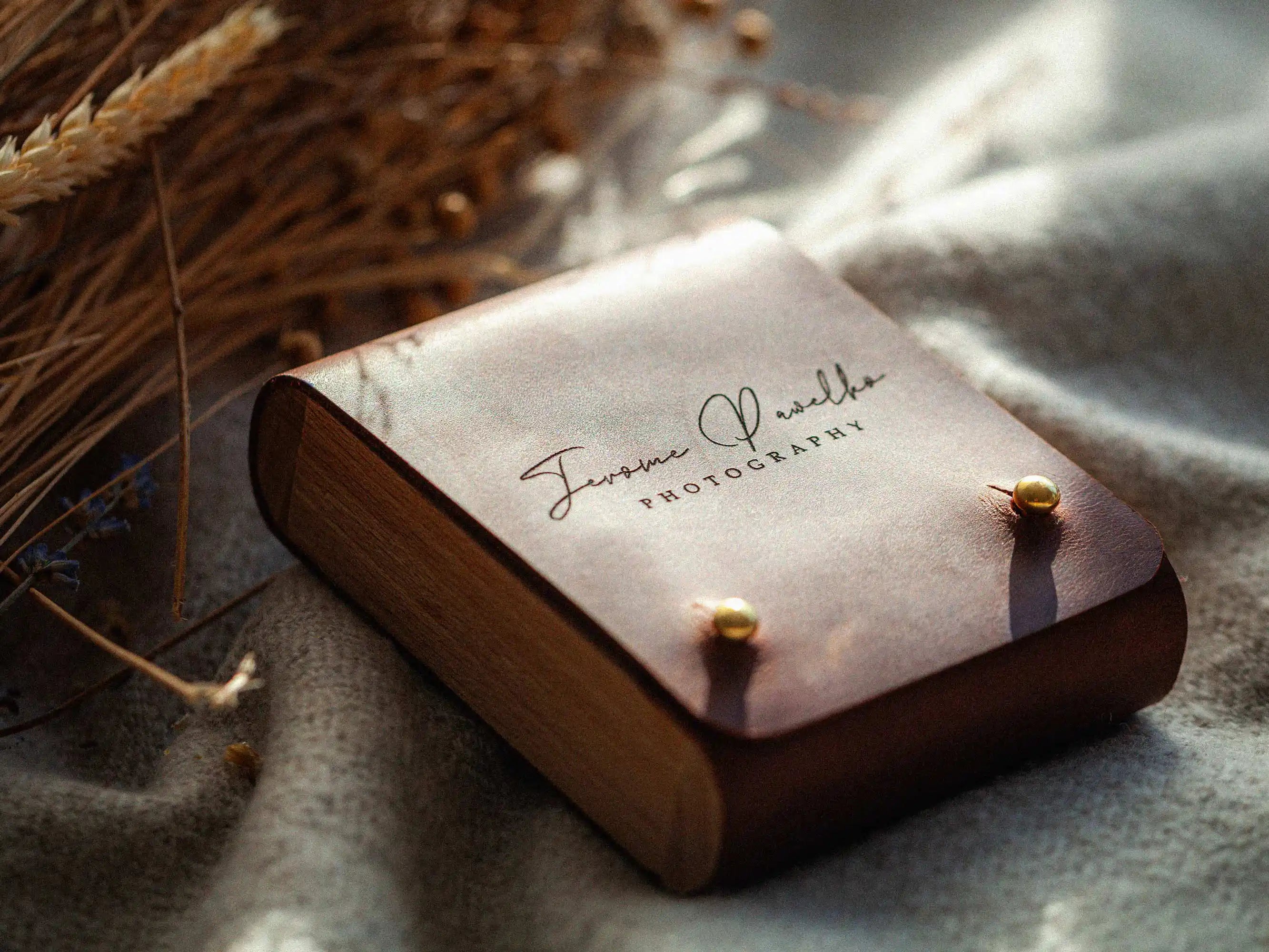 Cognac leather USB box on blanket, angled view showing wooden side detail