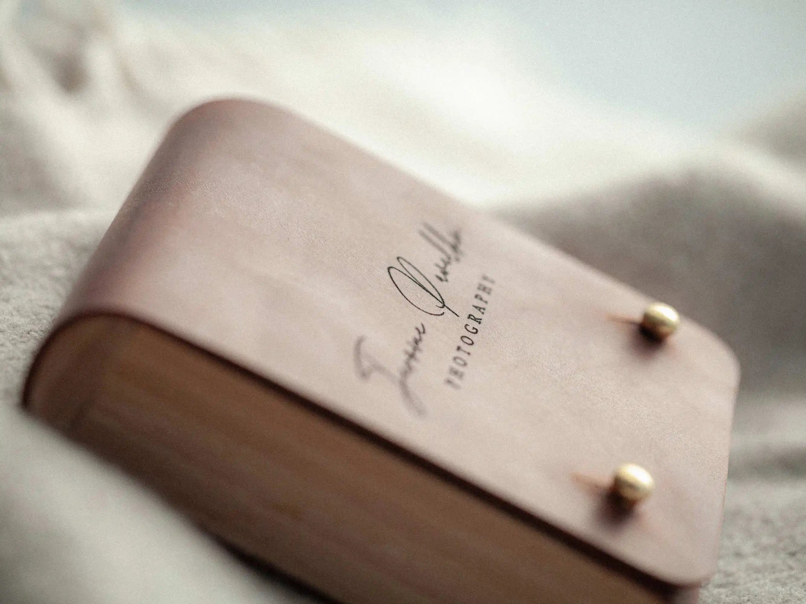 Close-up cognac leather lid and brass studs, engraved logo visible