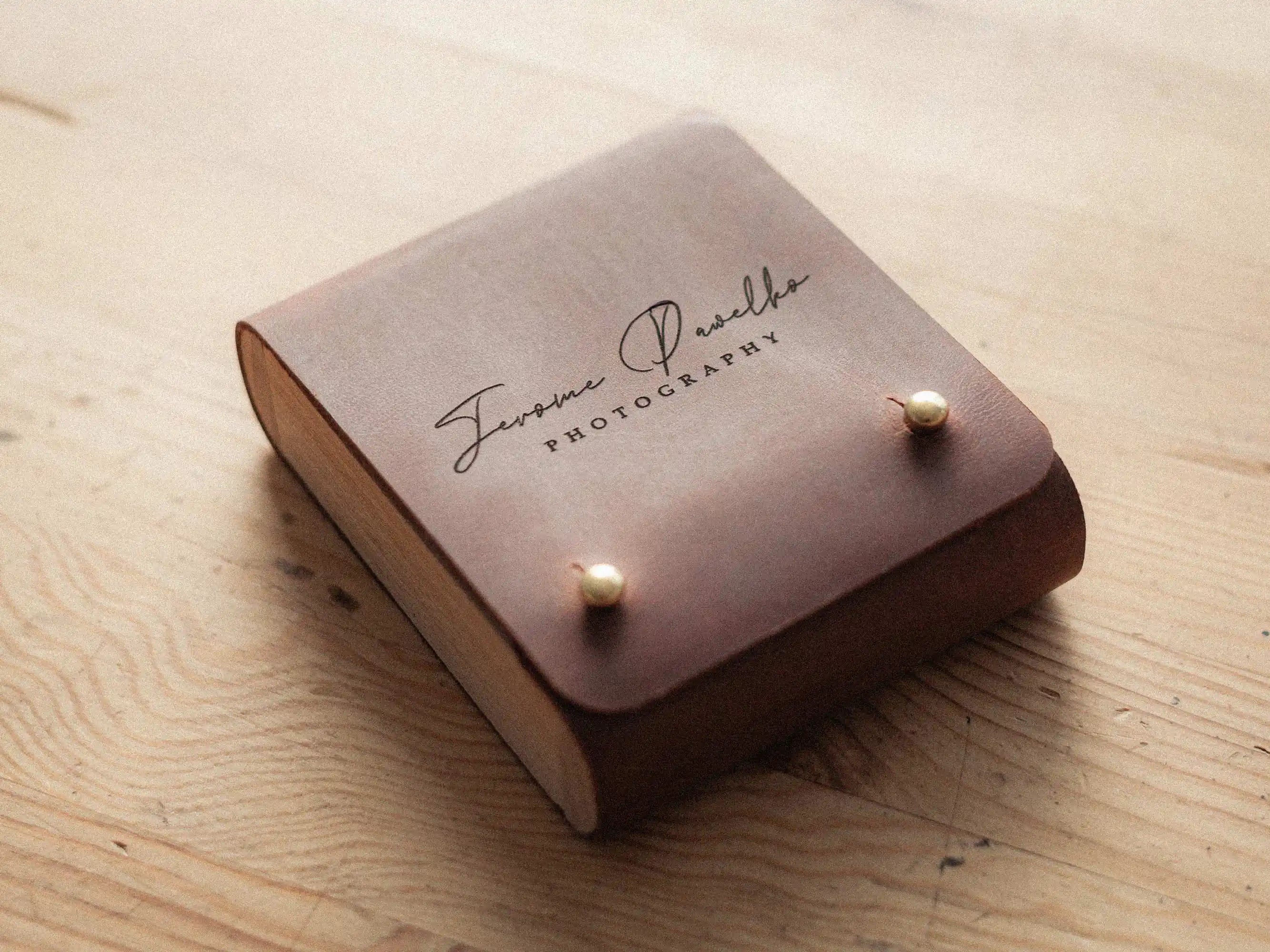 Cognac leather USB box with engraved logo, closed on wooden table