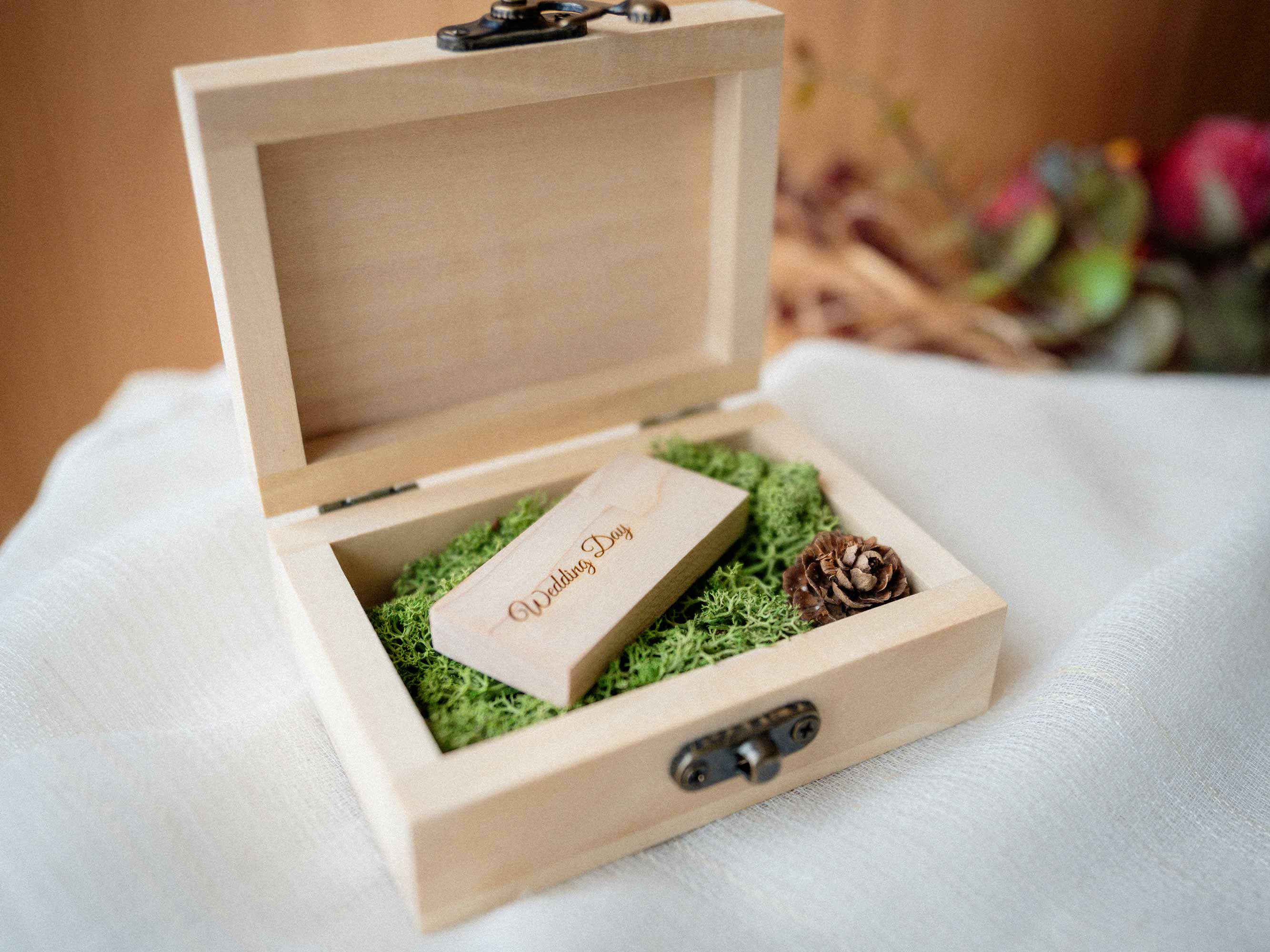 Open natural wooden USB box with wooden flash drive and moss