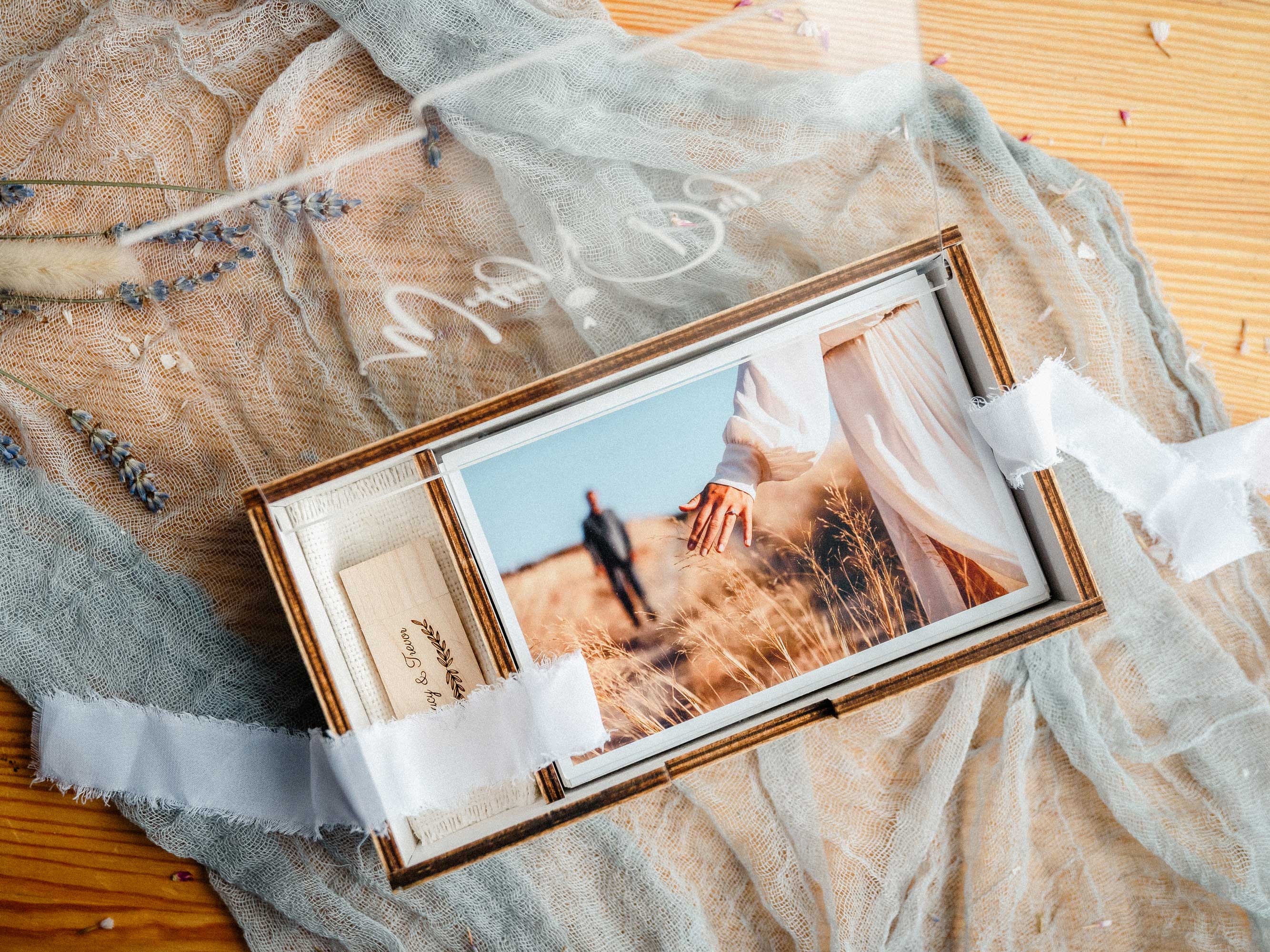 White wedding photo box with USB, personalized acrylic lid, and printed photos on soft fabric