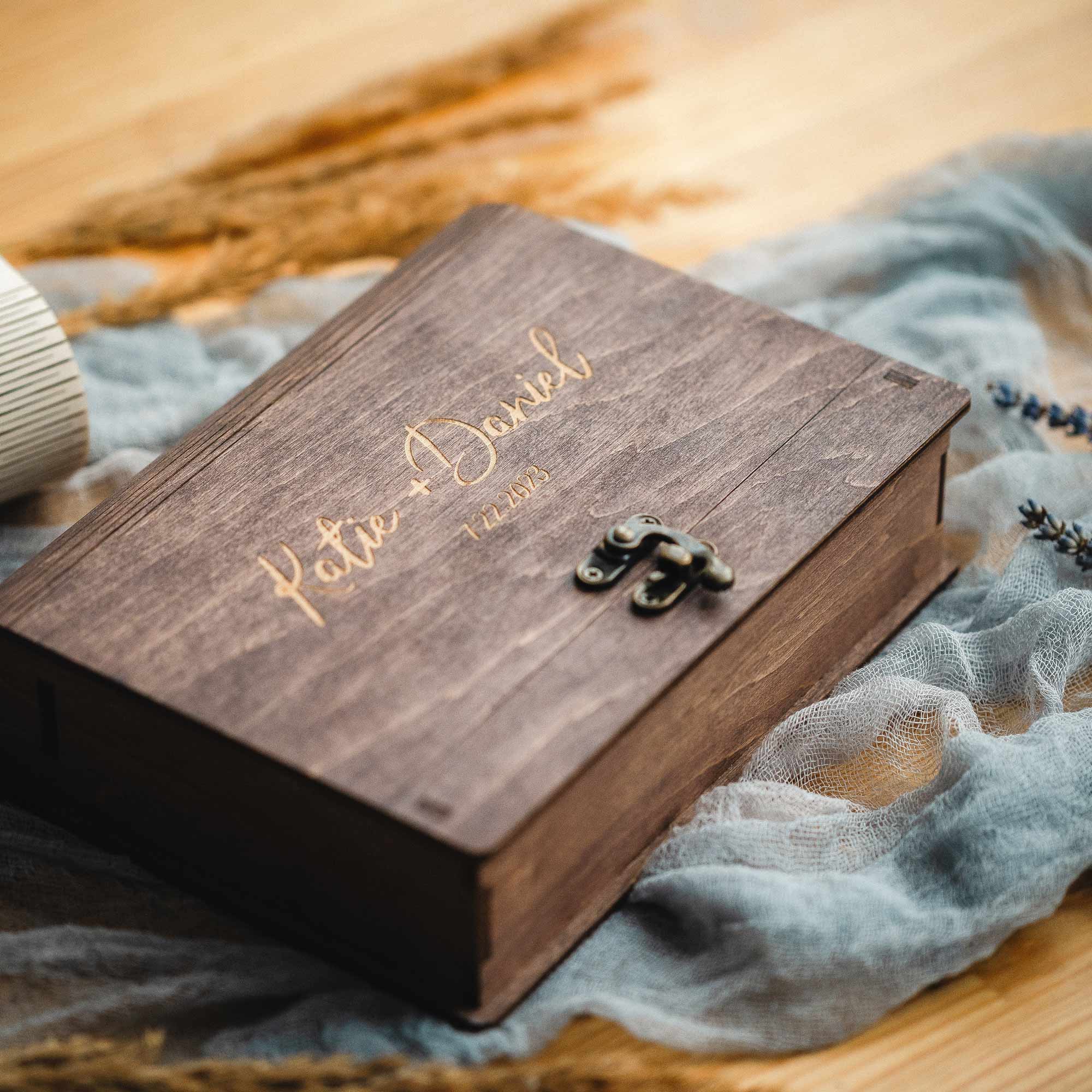 Open walnut box flatlay with prints and matching wooden USB drives