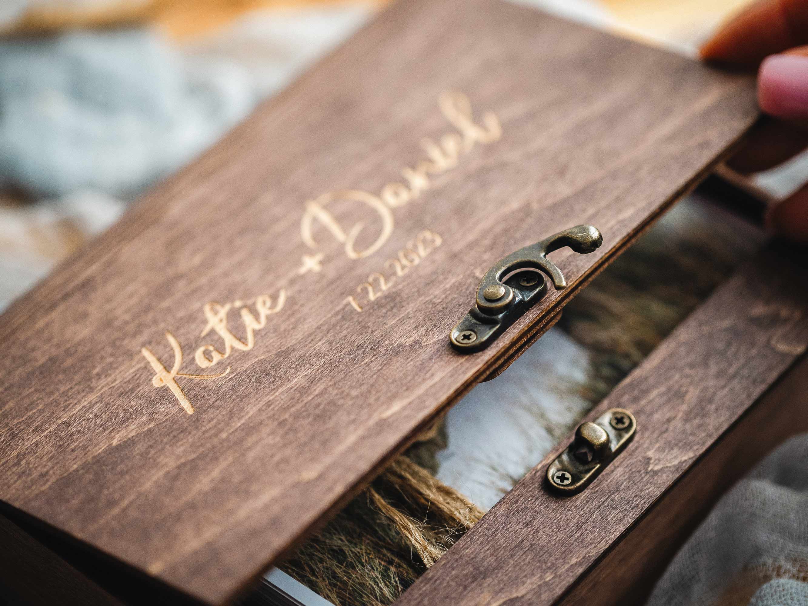 Close-up of personalized engraving and vintage hook on walnut wooden box
