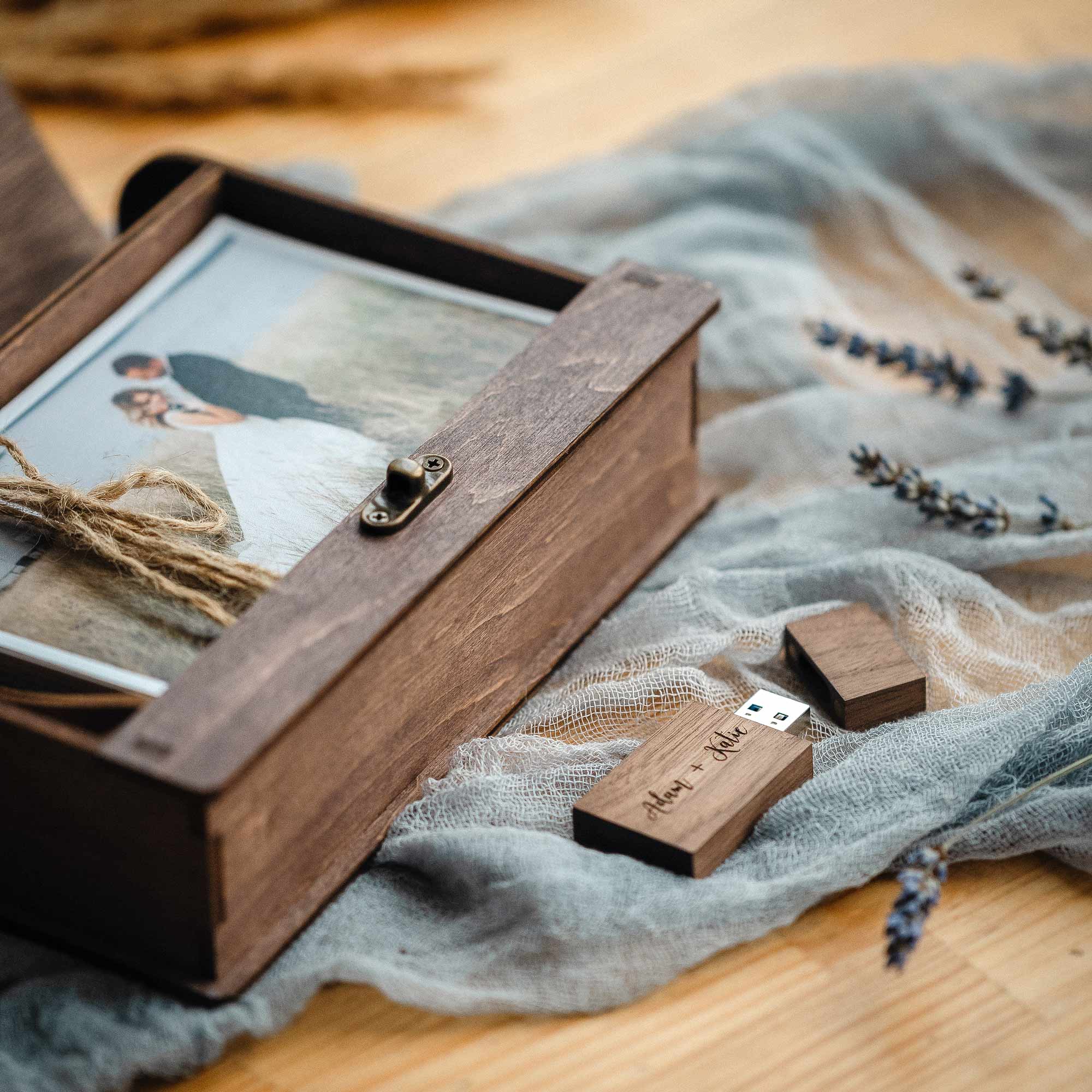 Closed walnut photo box held on lap, vintage latch and engraving