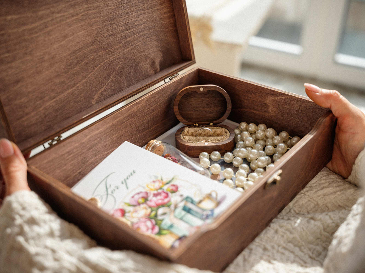 Open wooden wedding memory box filled with jewelry, letters and keepsakes