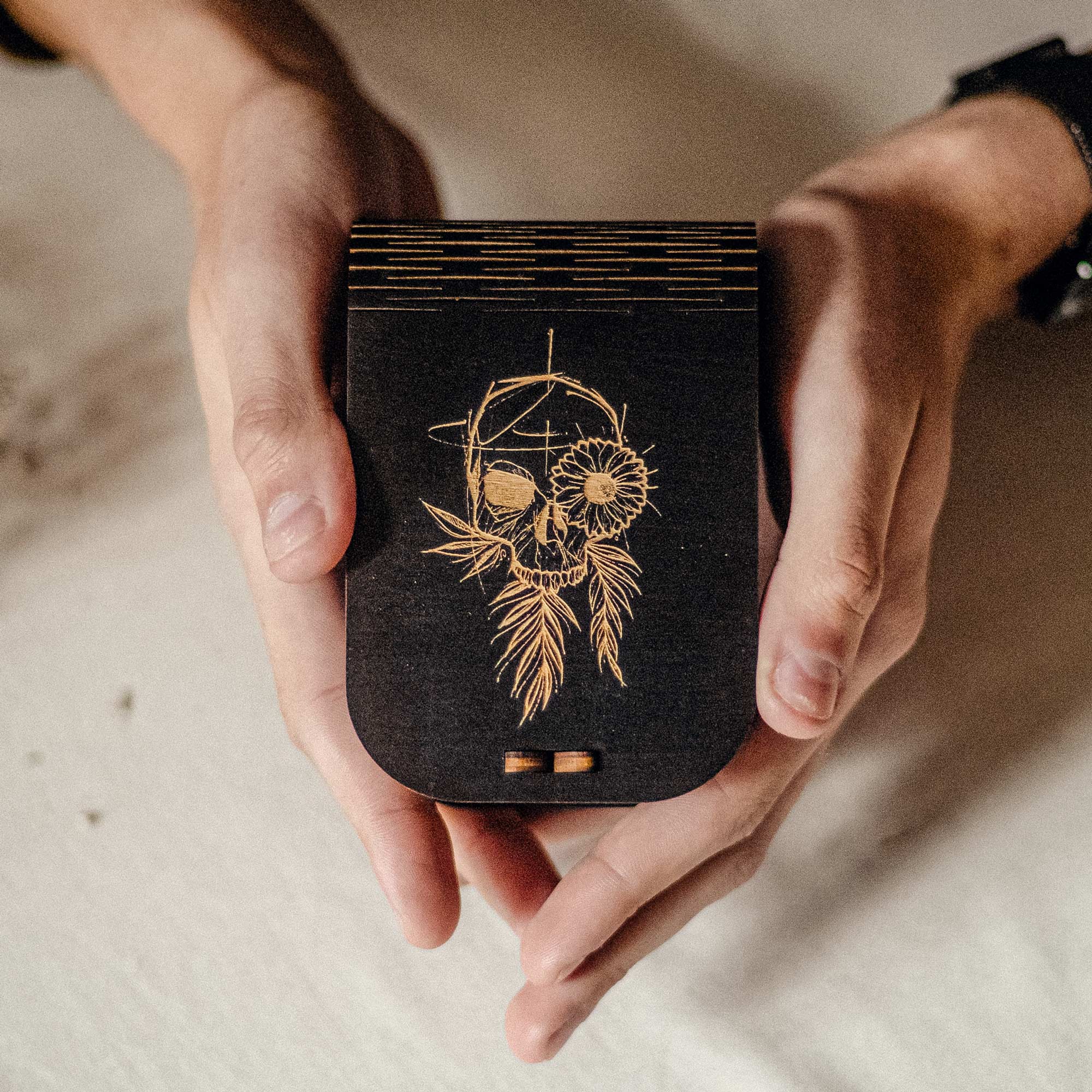 Personalized black wooden USB box with gold skull engraving held in hands