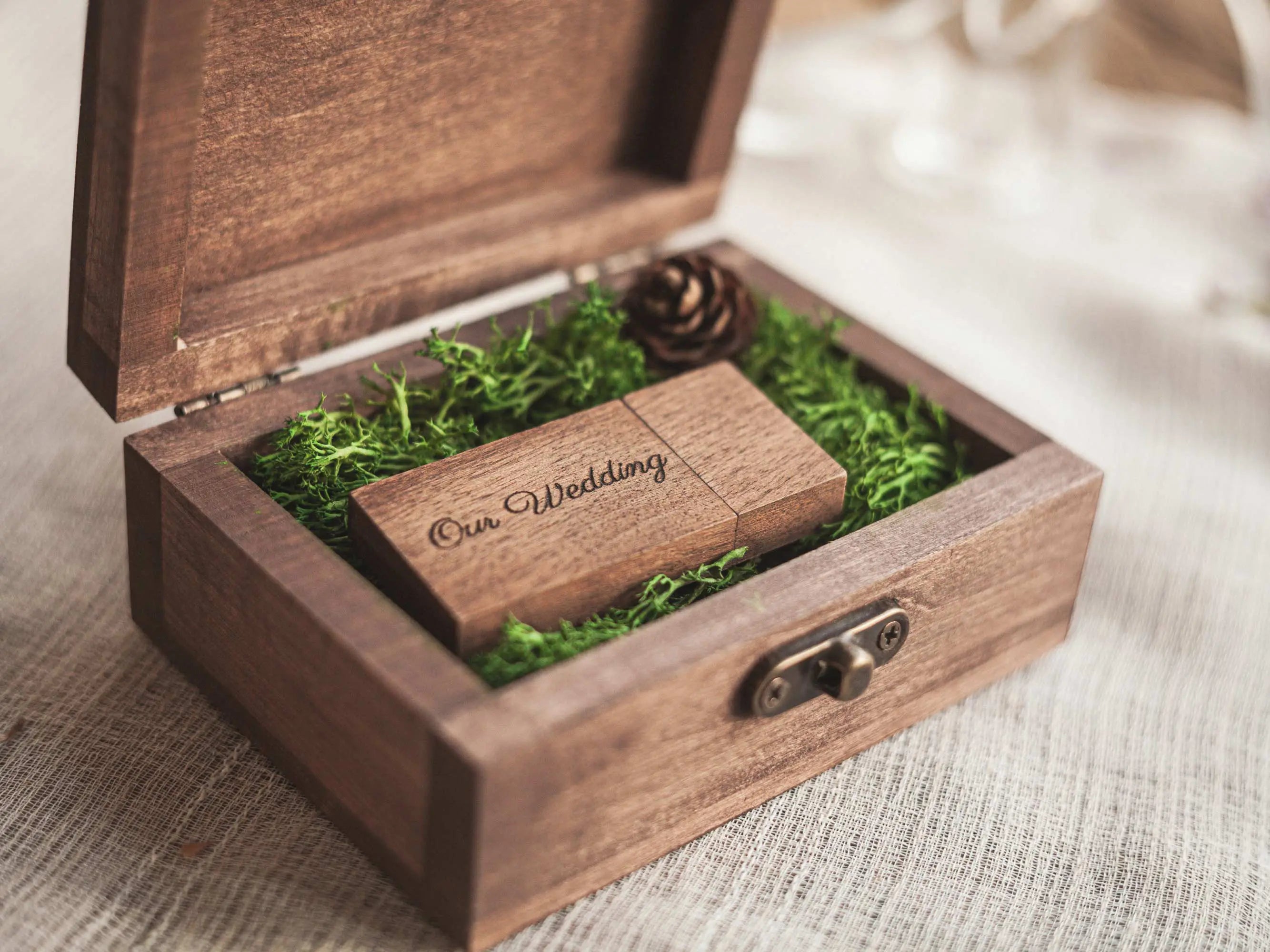 Open engraved wooden keepsake box showing moss insert, premium wedding USB packaging.