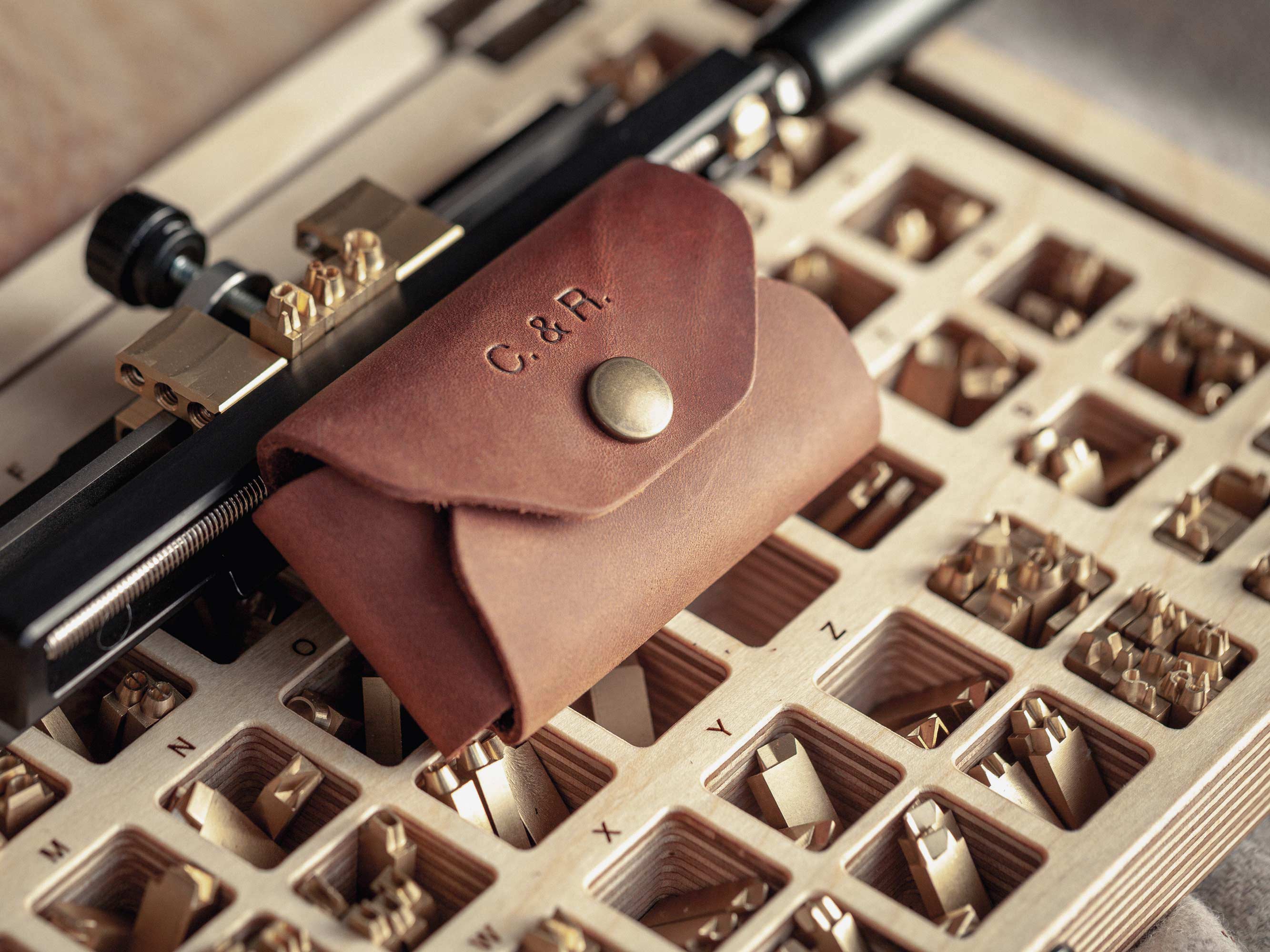 Cognac leather USB case with hot-stamped initials on brass letter tray
