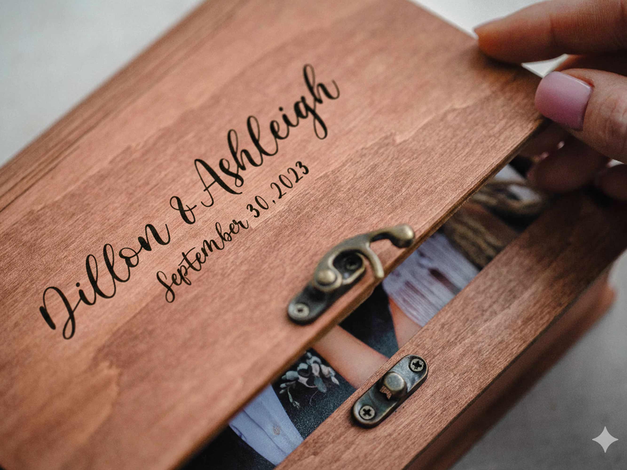 Closeup of engraved teak photo box lid with vintage metal hook closure