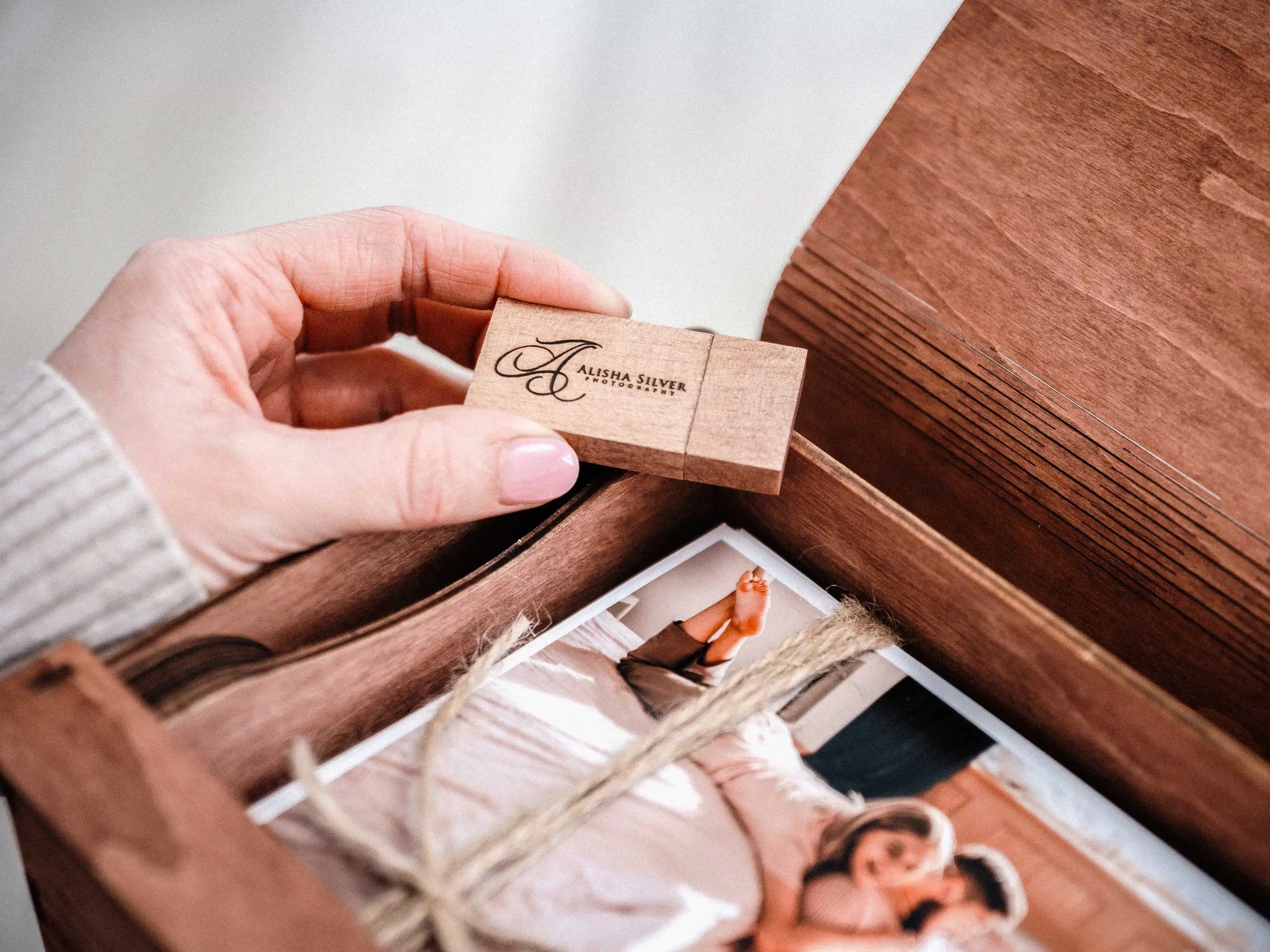 Personalized wooden USB flash drive above open teak photo keepsake box