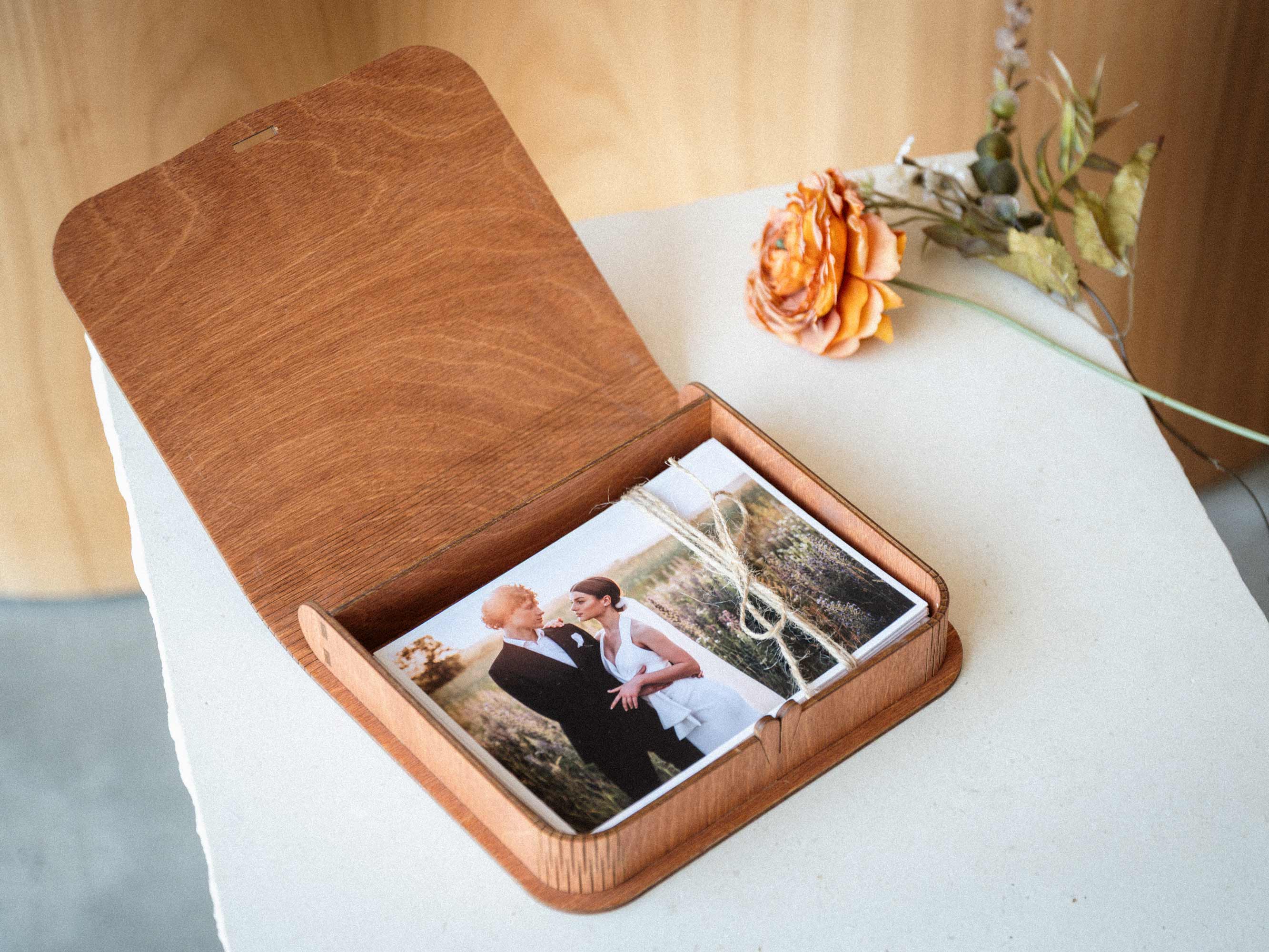 Open teak keepsake photo box with bundled prints inside