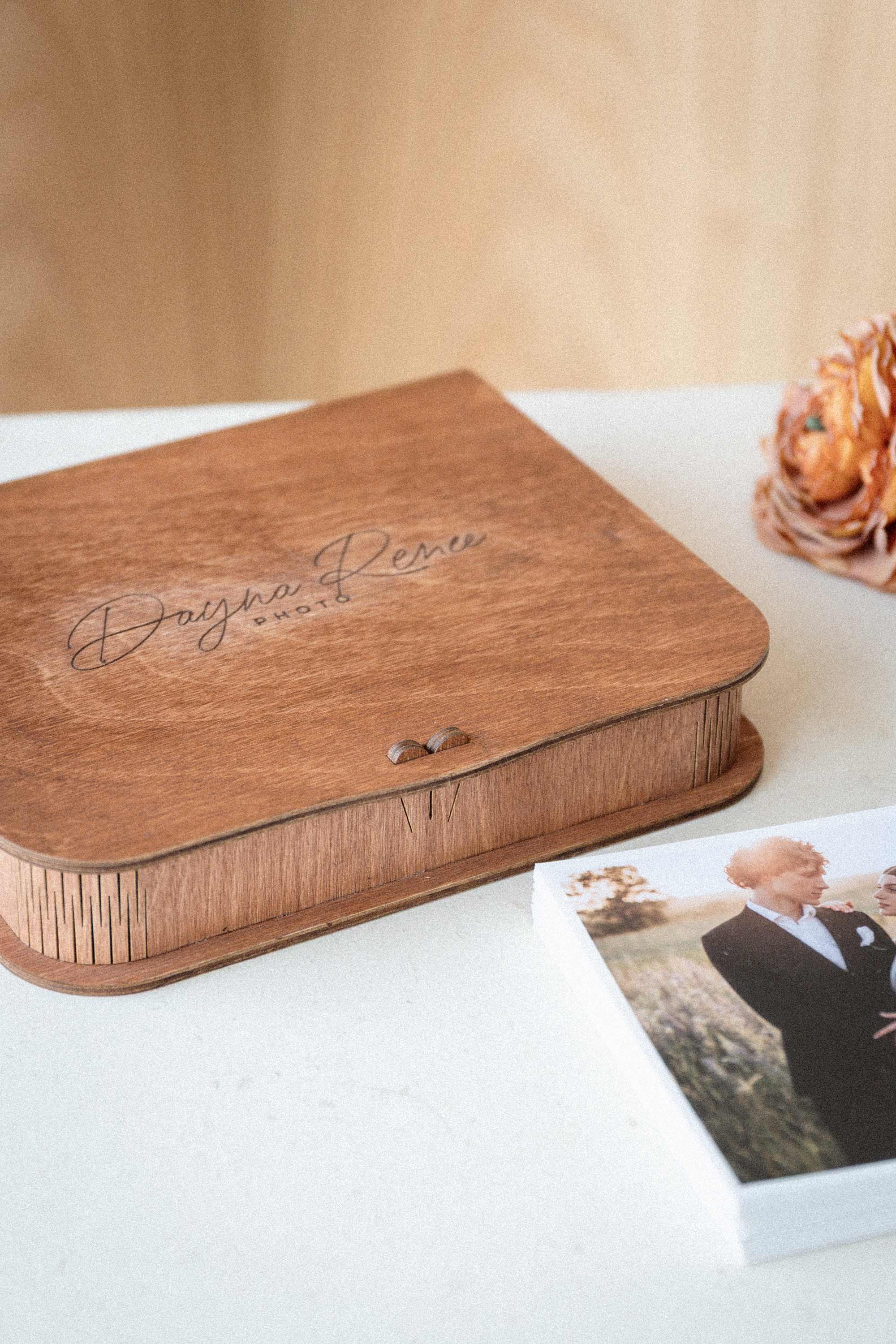 Closed engraved teak photo keepsake box with loose print beside it