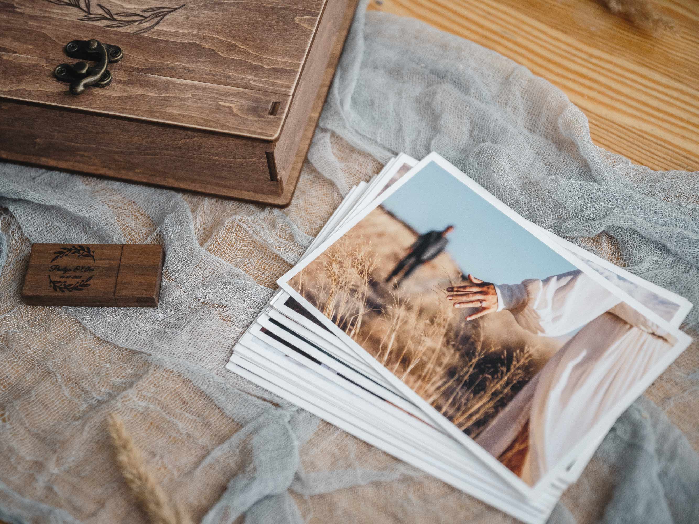 Walnut wedding photo box with wooden USB and photo prints styled on linen for photographer client reveal