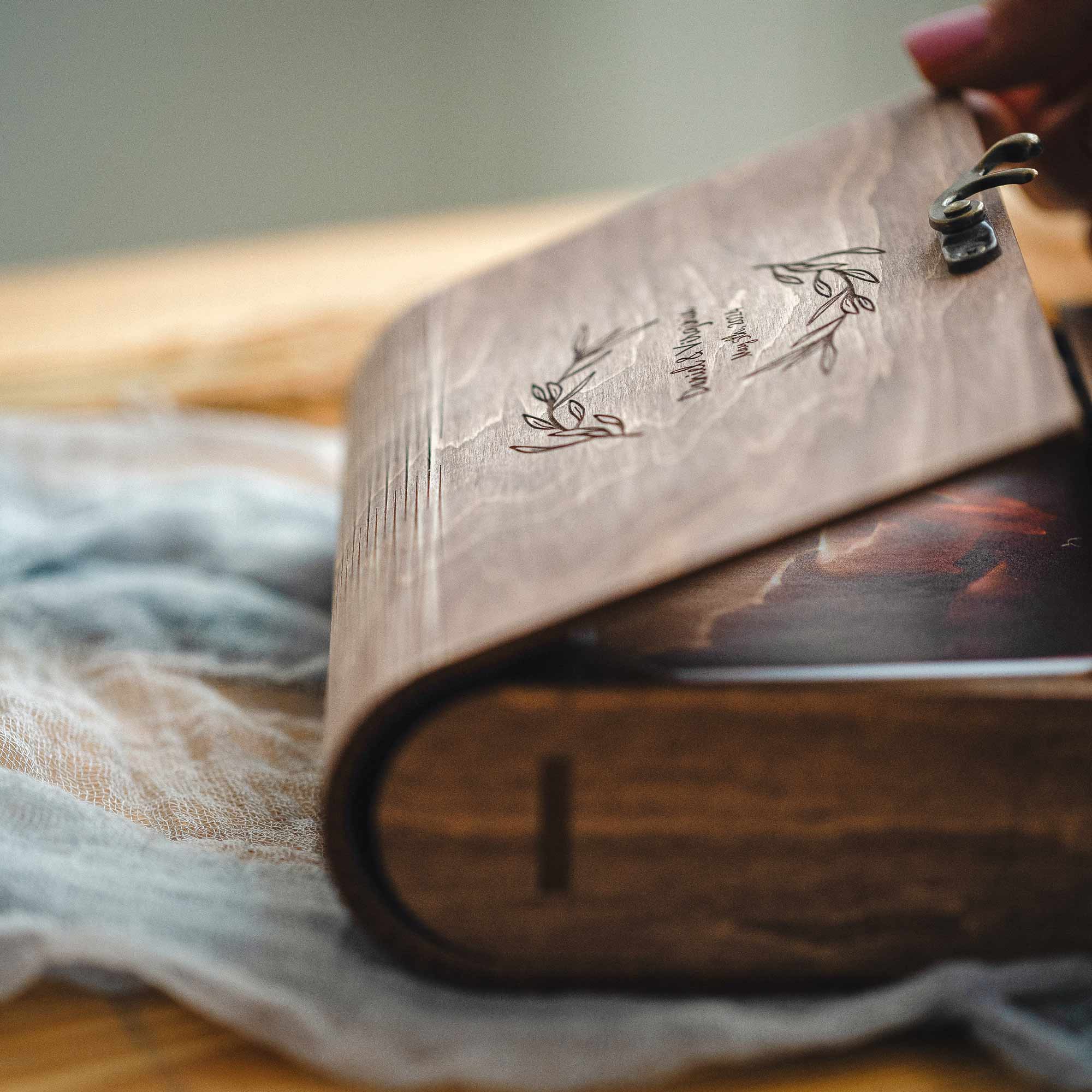 Side view of vintage walnut photo box with rounded spine and engraved lid, book-style keepsake