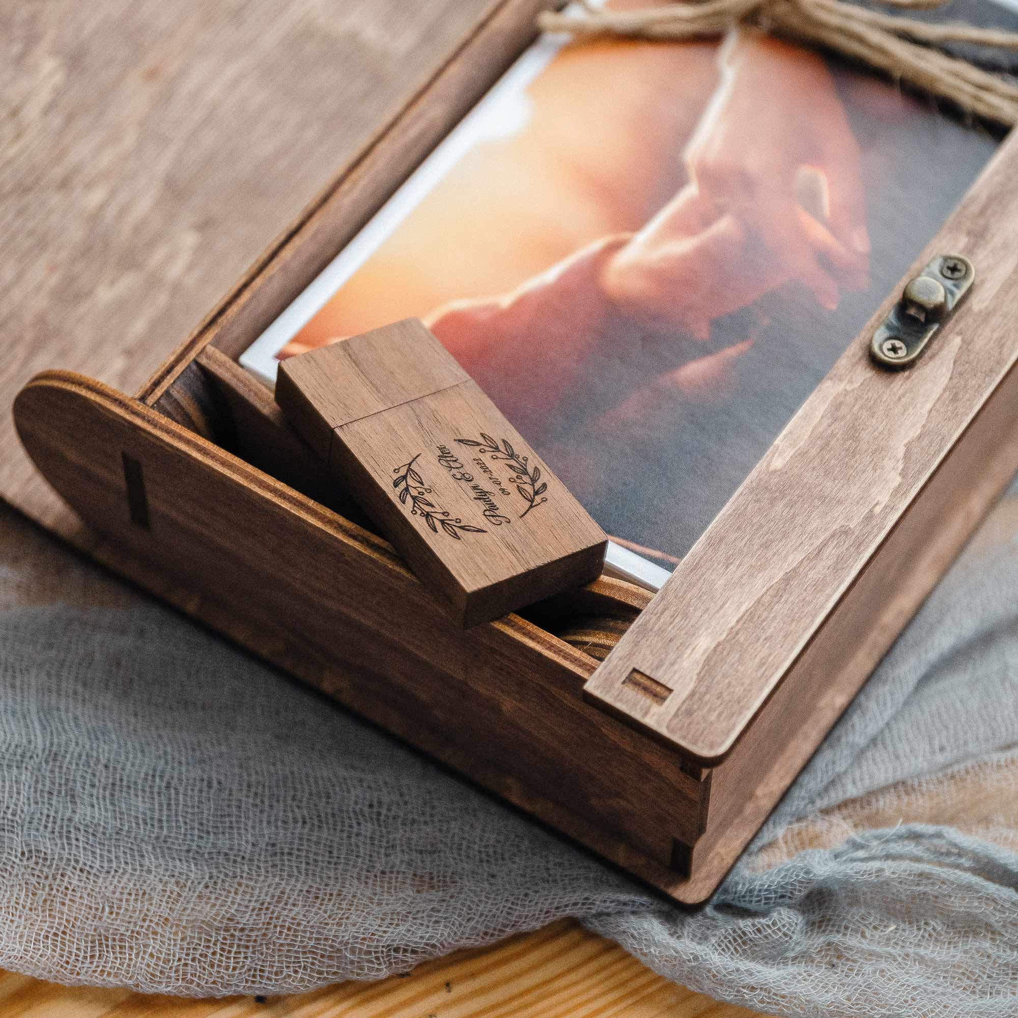 Open walnut photo box with photo prints and wooden USB stored together for all-in-one wedding keepsake