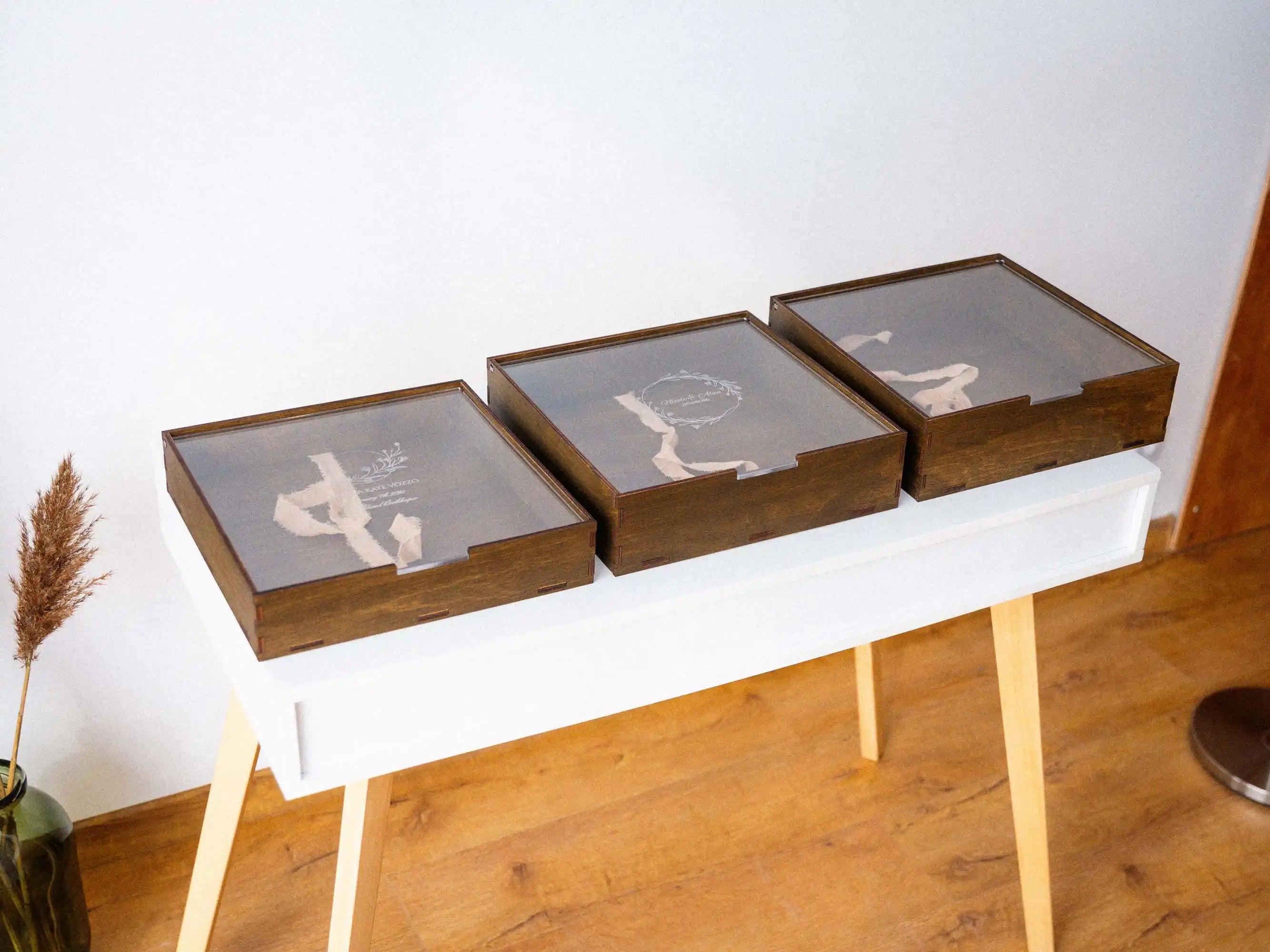 Set of walnut wooden gift boxes with acrylic lids displayed on a table