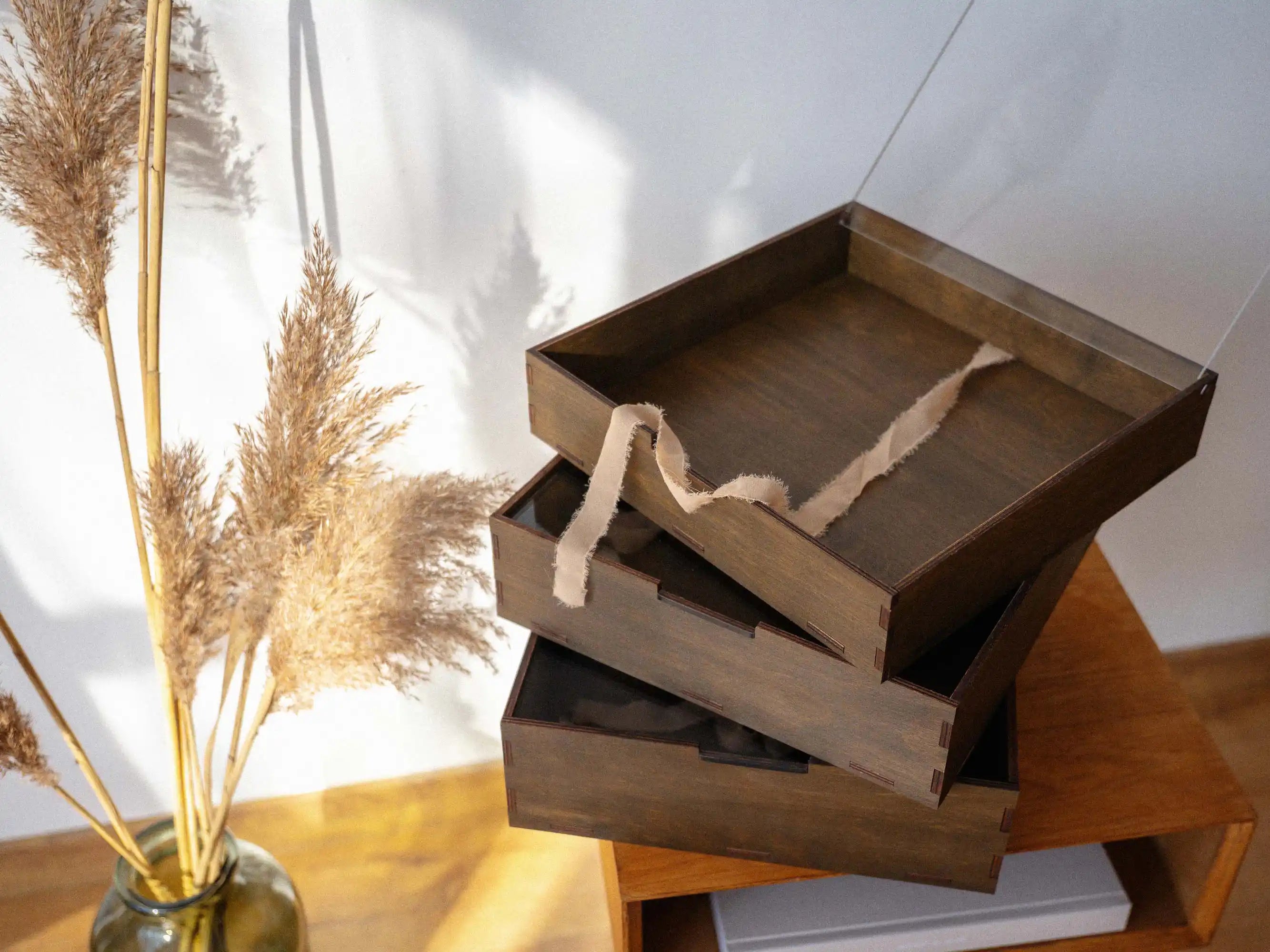 Stack of open walnut wedding album boxes showing multiple depth options