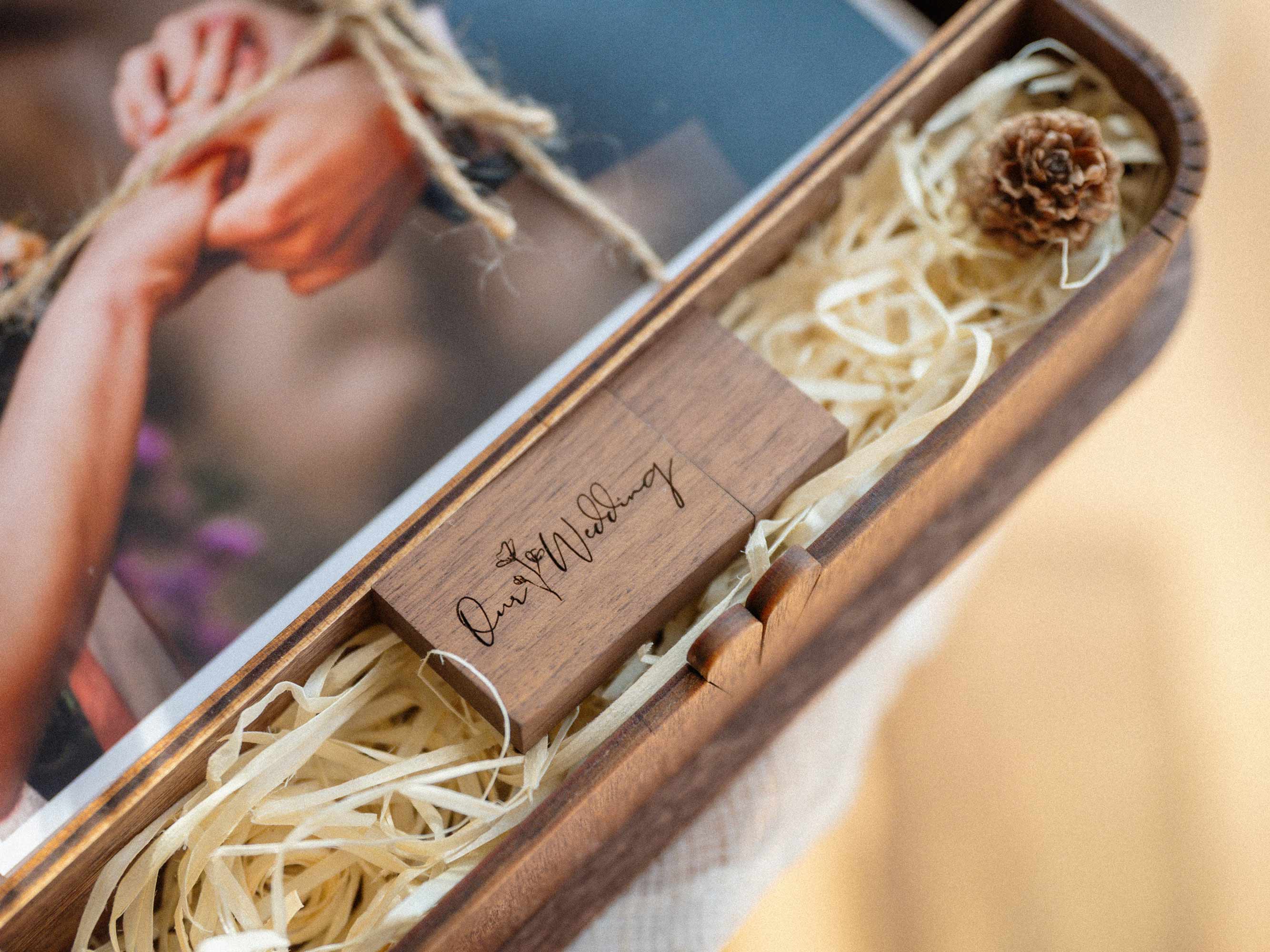 Close up of engraved wooden USB inside walnut photo box