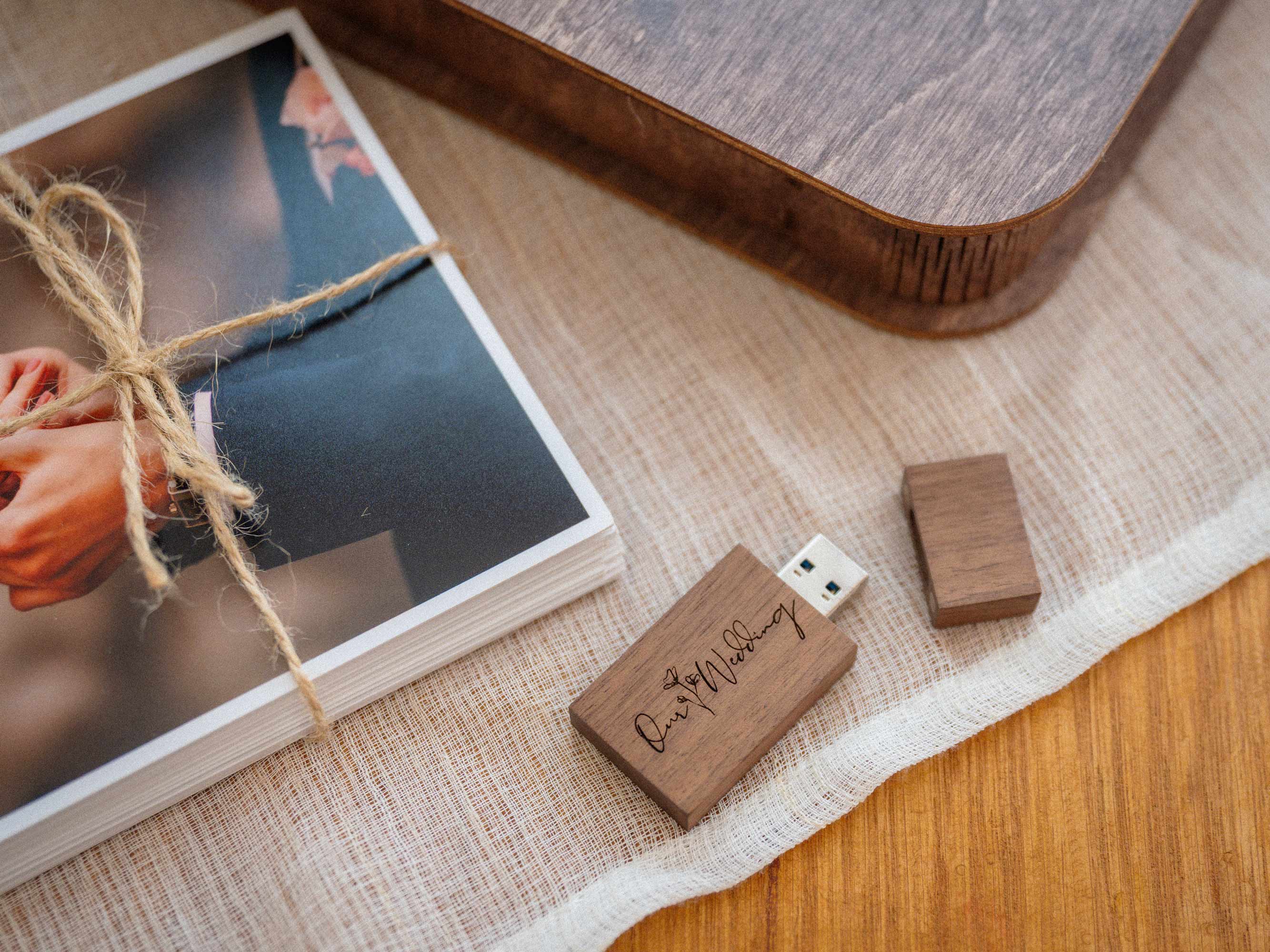 Wooden USB flash drive next to wedding prints and walnut photo box