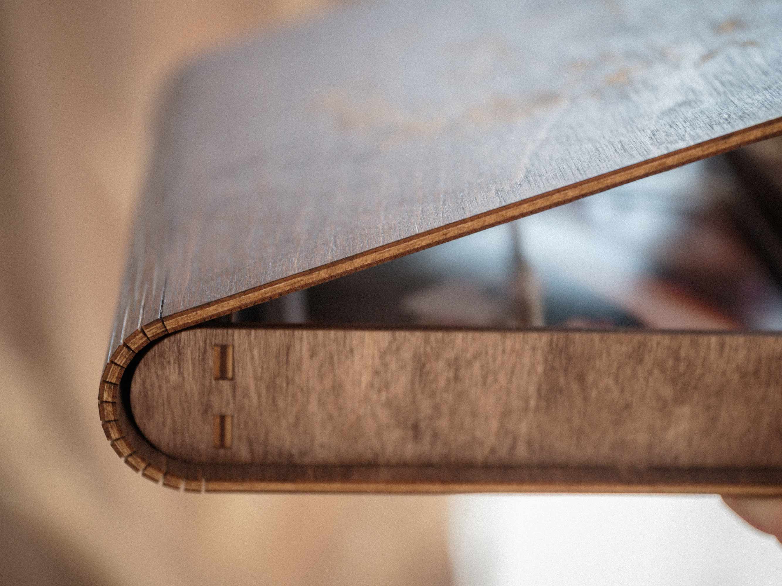 Side detail of walnut wooden photo box with curved lid and wood grain