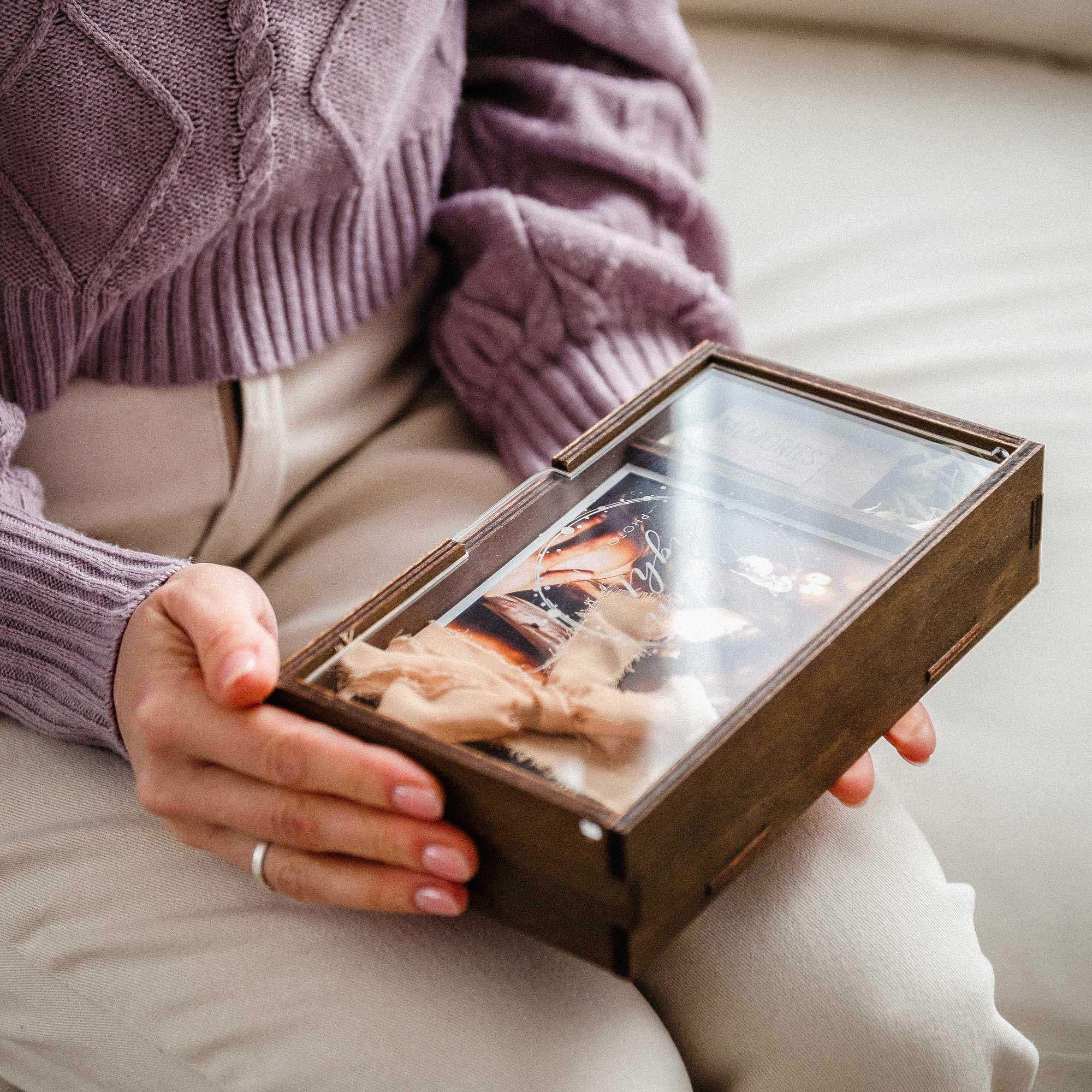 Woman holding a wooden wedding photo box with personalized acrylic lid