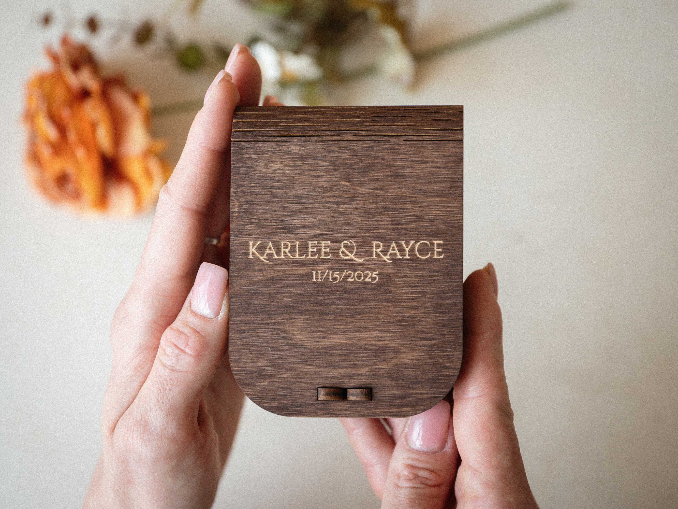 Walnut wedding USB box with engraved names held in hands