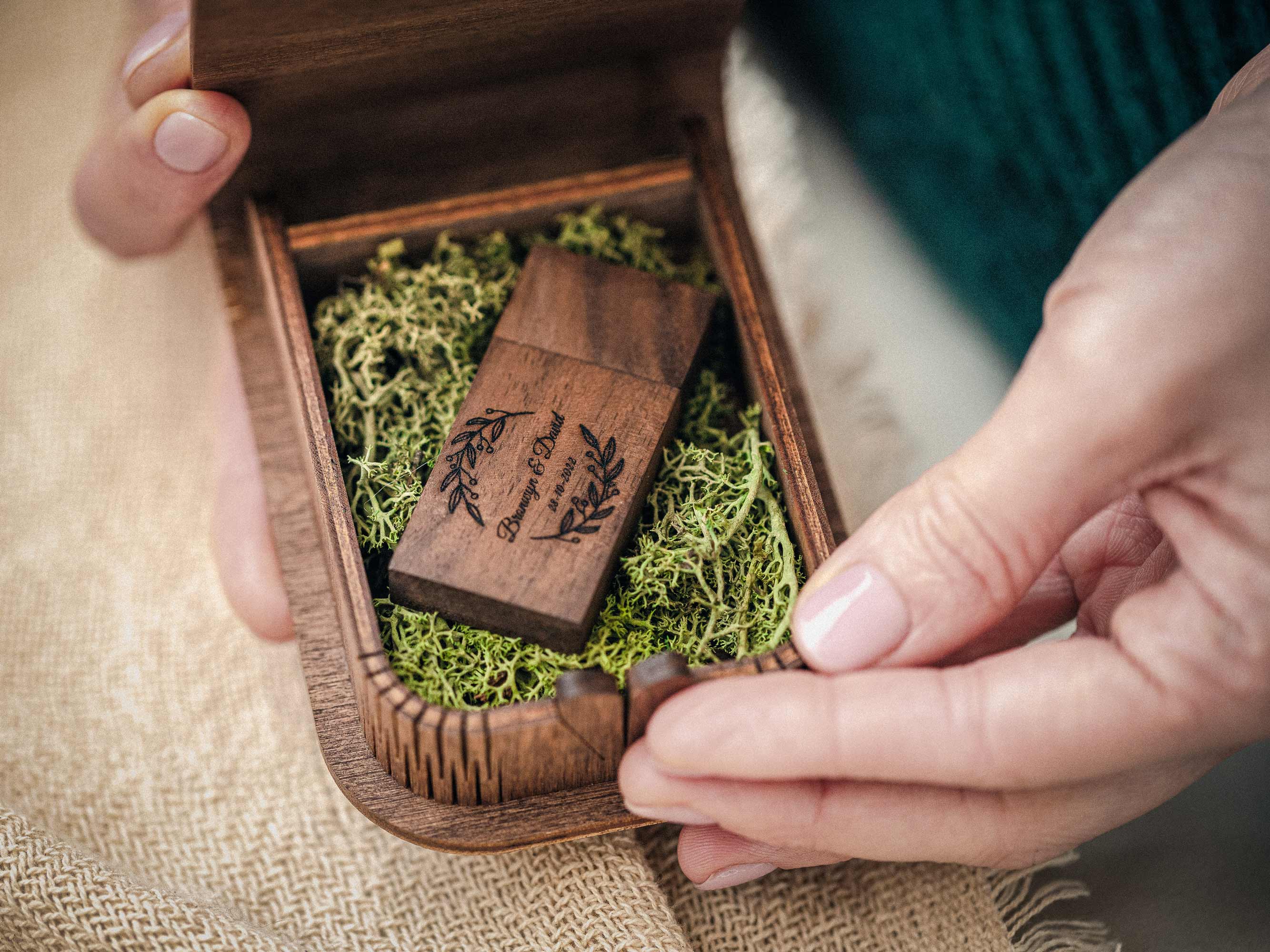 Personalized walnut wedding USB box with wooden flash drive held in hands