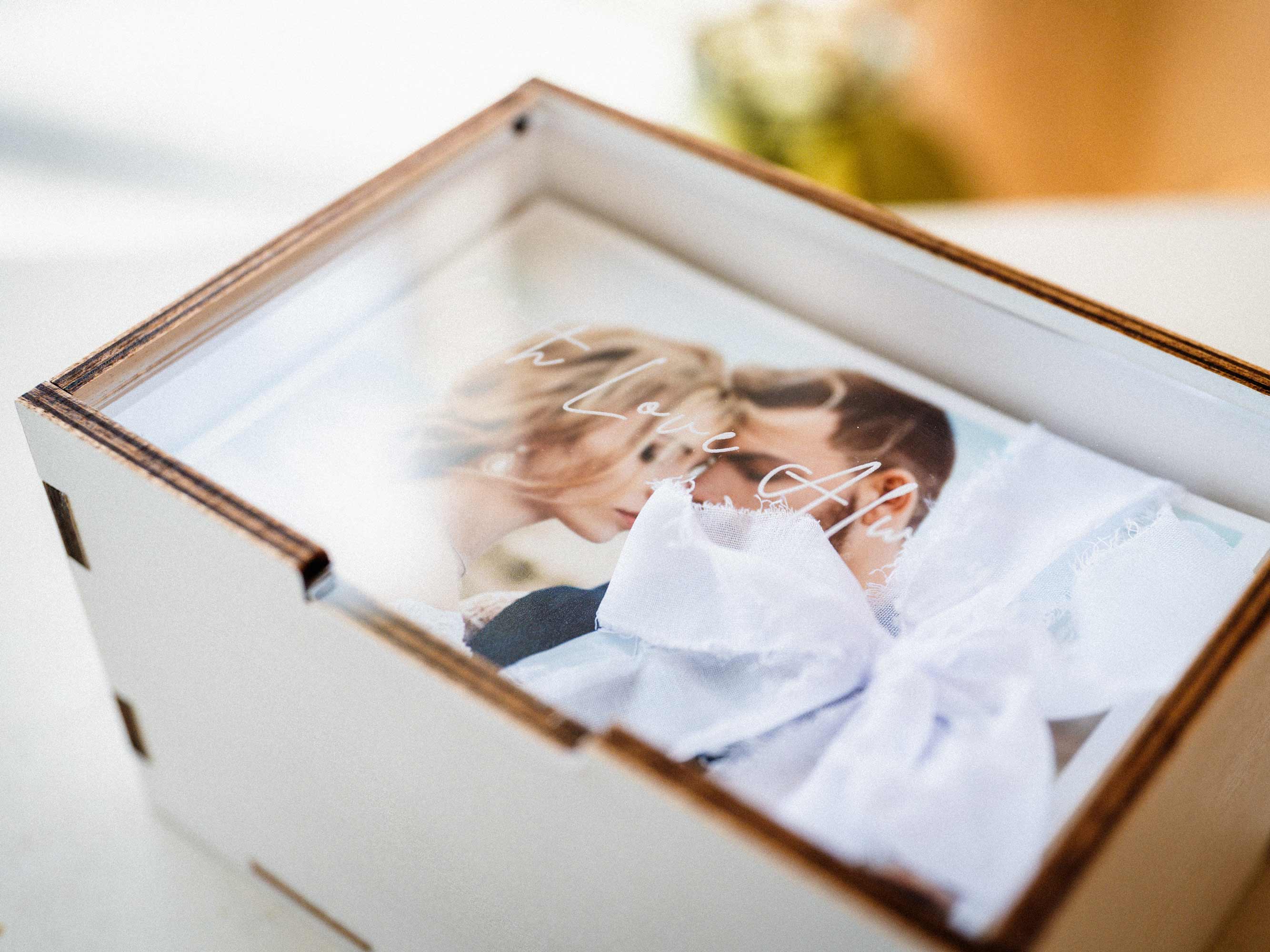 Close-up of white wooden photo box with wedding print inside