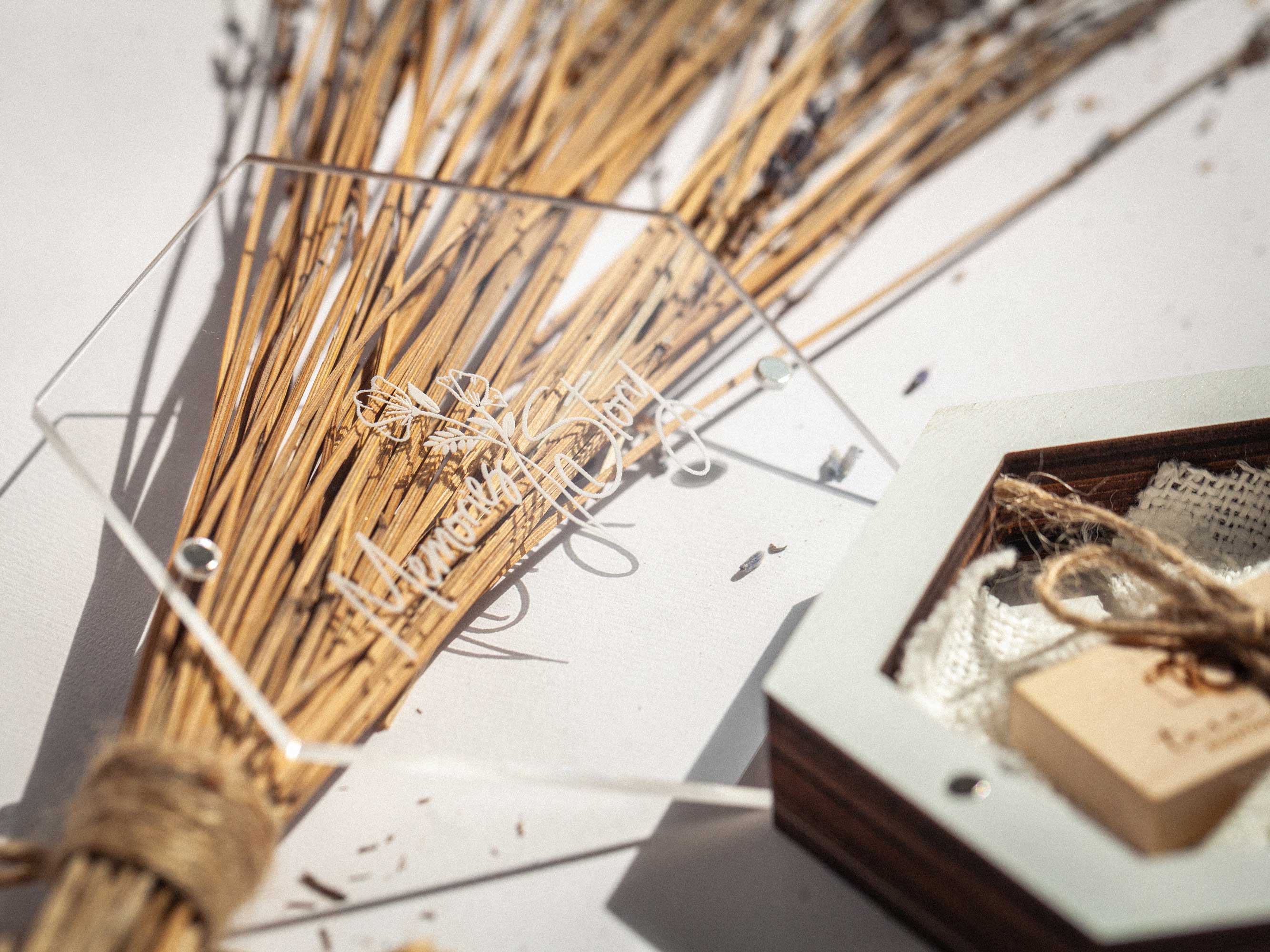 White wedding USB box with acrylic lid and wooden flash drive on dried grass background
