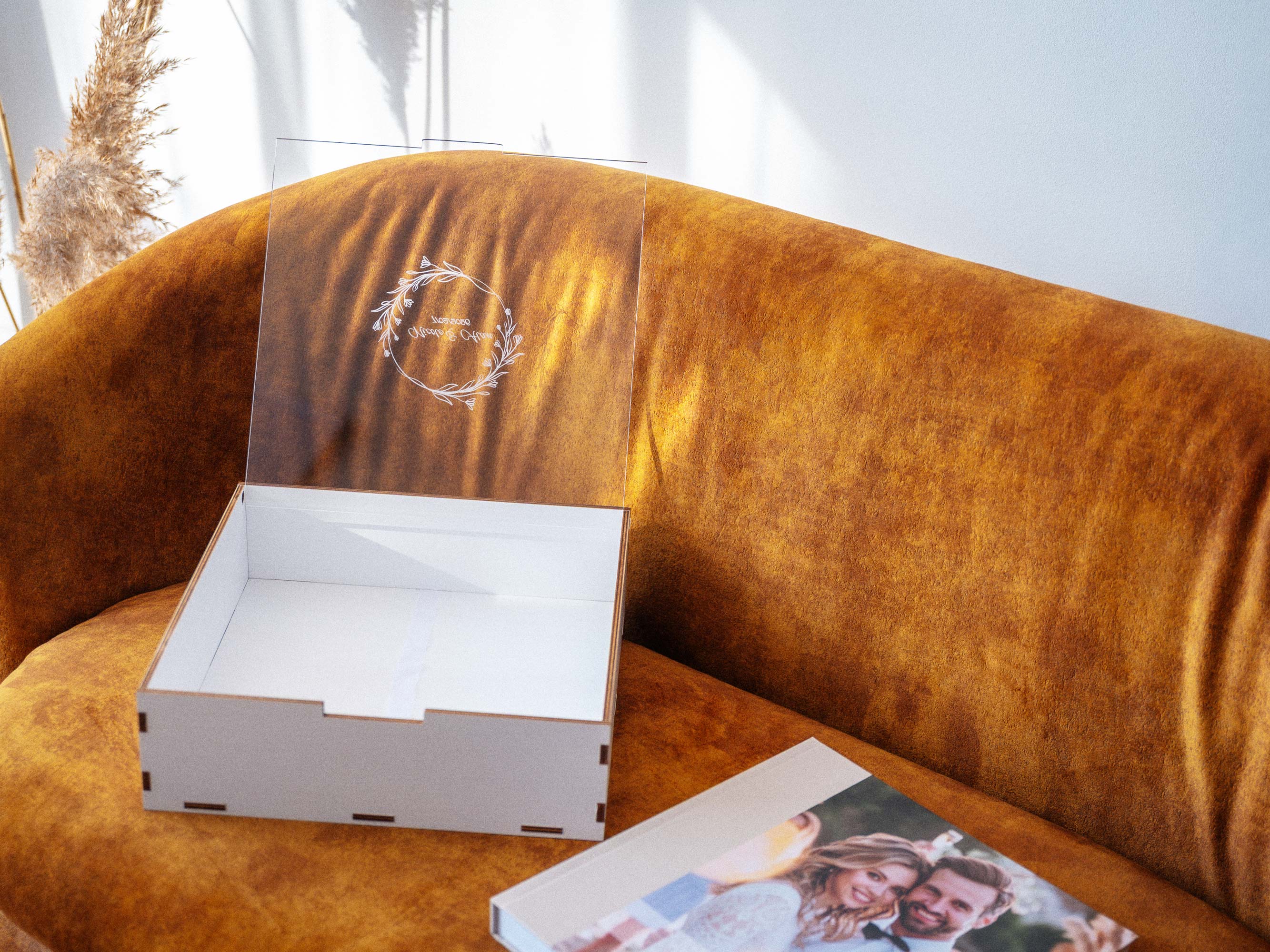 White wedding album box with acrylic lid open, empty box with album nearby