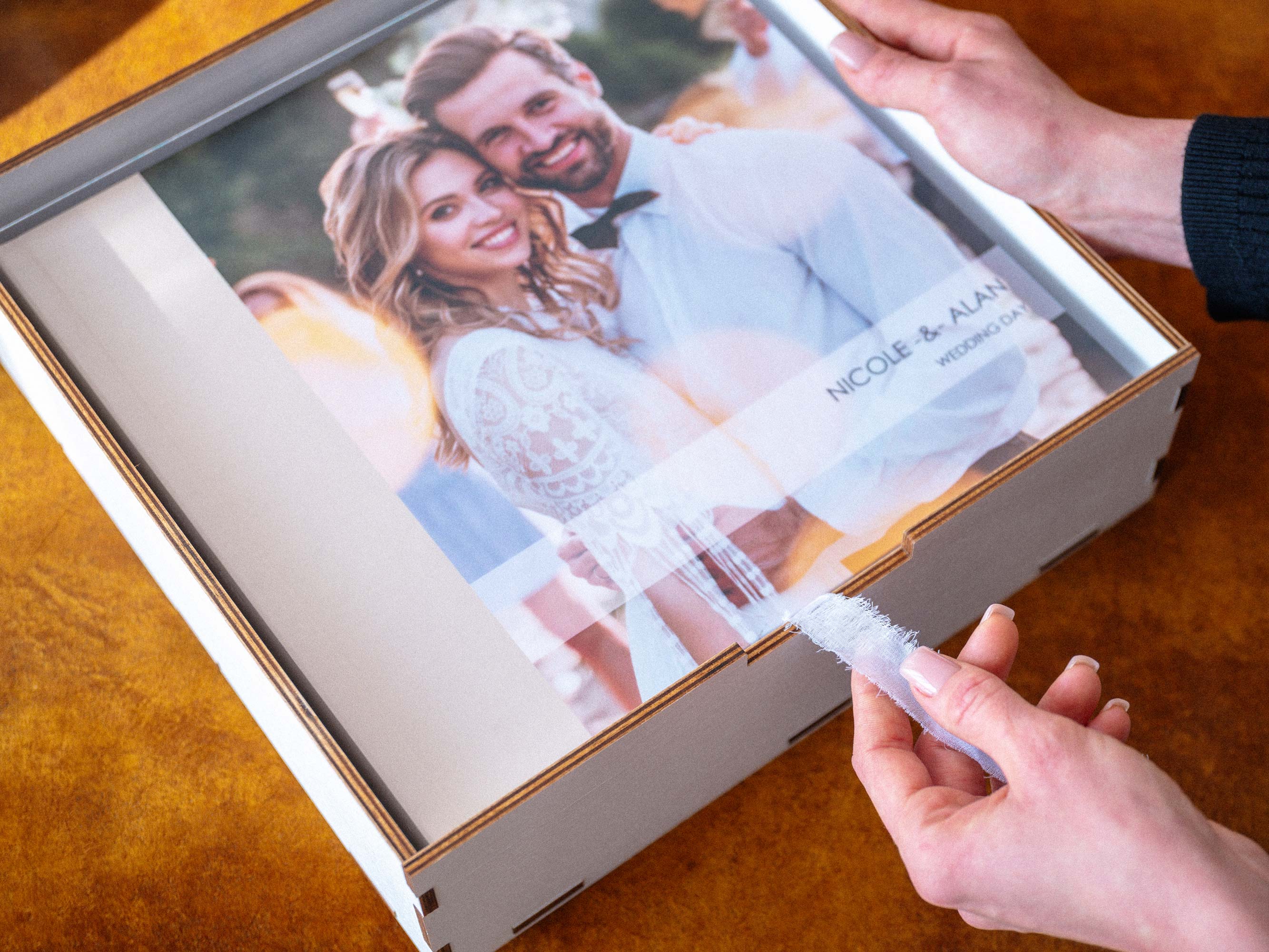 Close-up of white wooden box for 10x10 photo album with ribbon detail