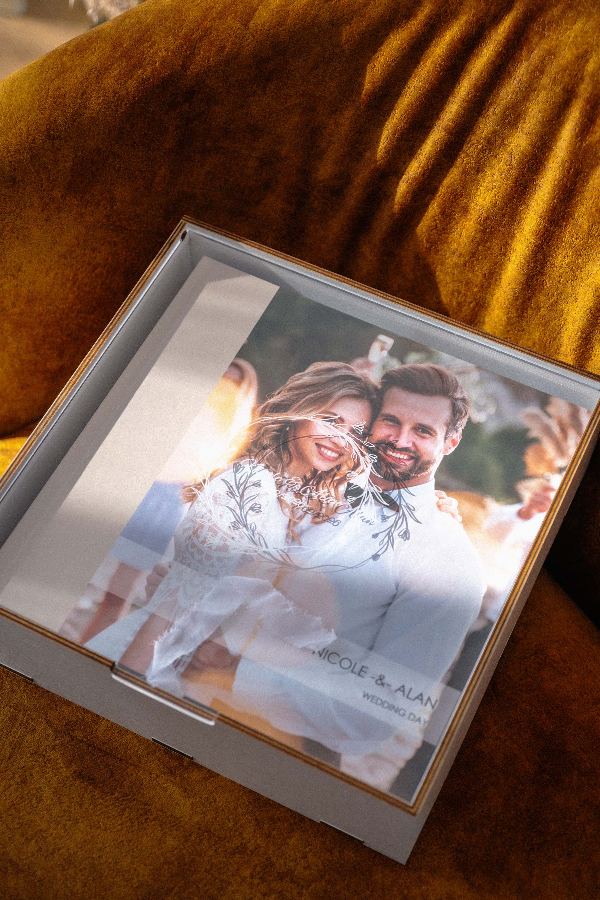 White wooden photo album box with acrylic lid closed over 10x10 wedding album