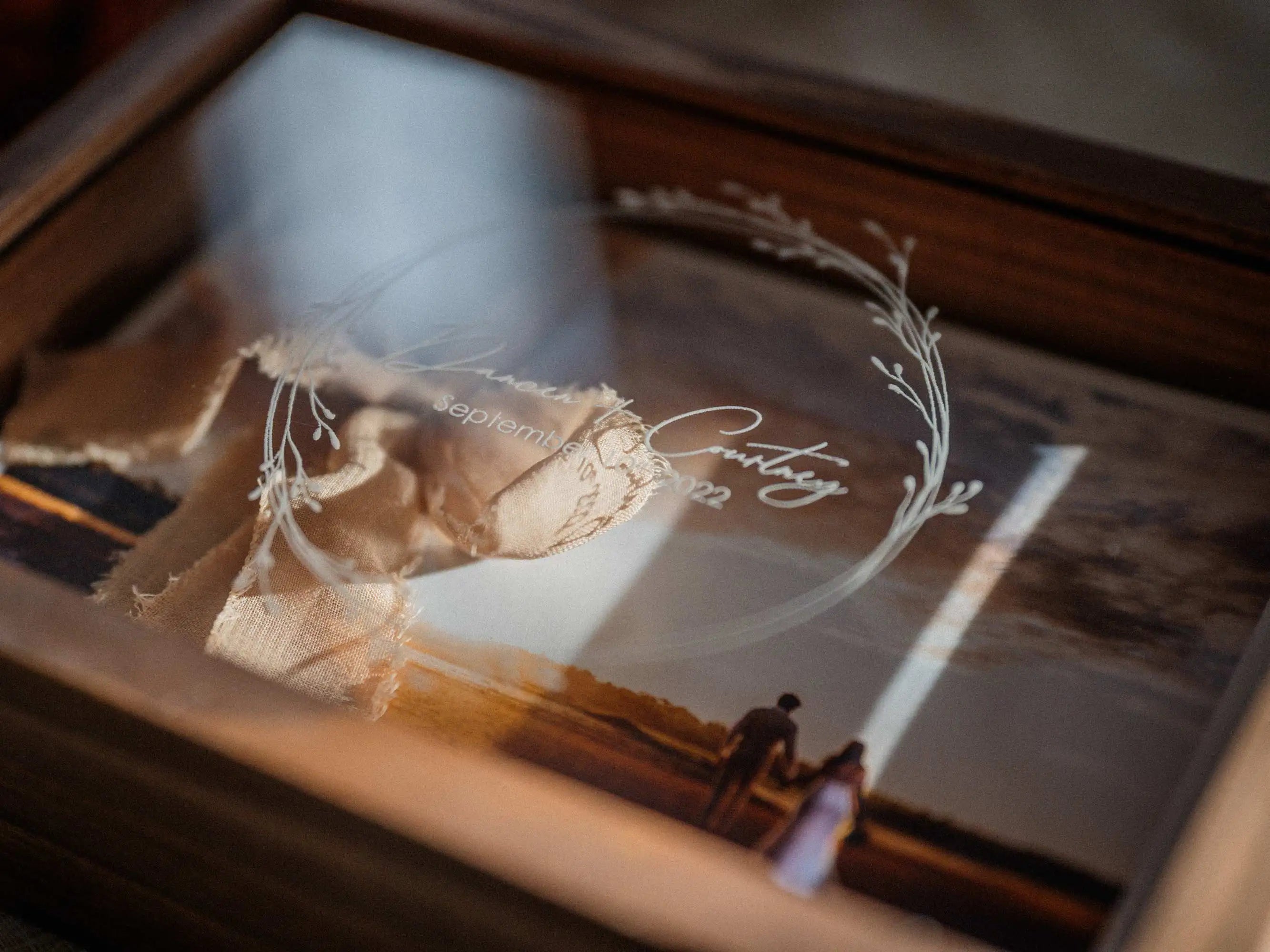 Close-up of wedding print inside walnut wooden photo box under acrylic lid