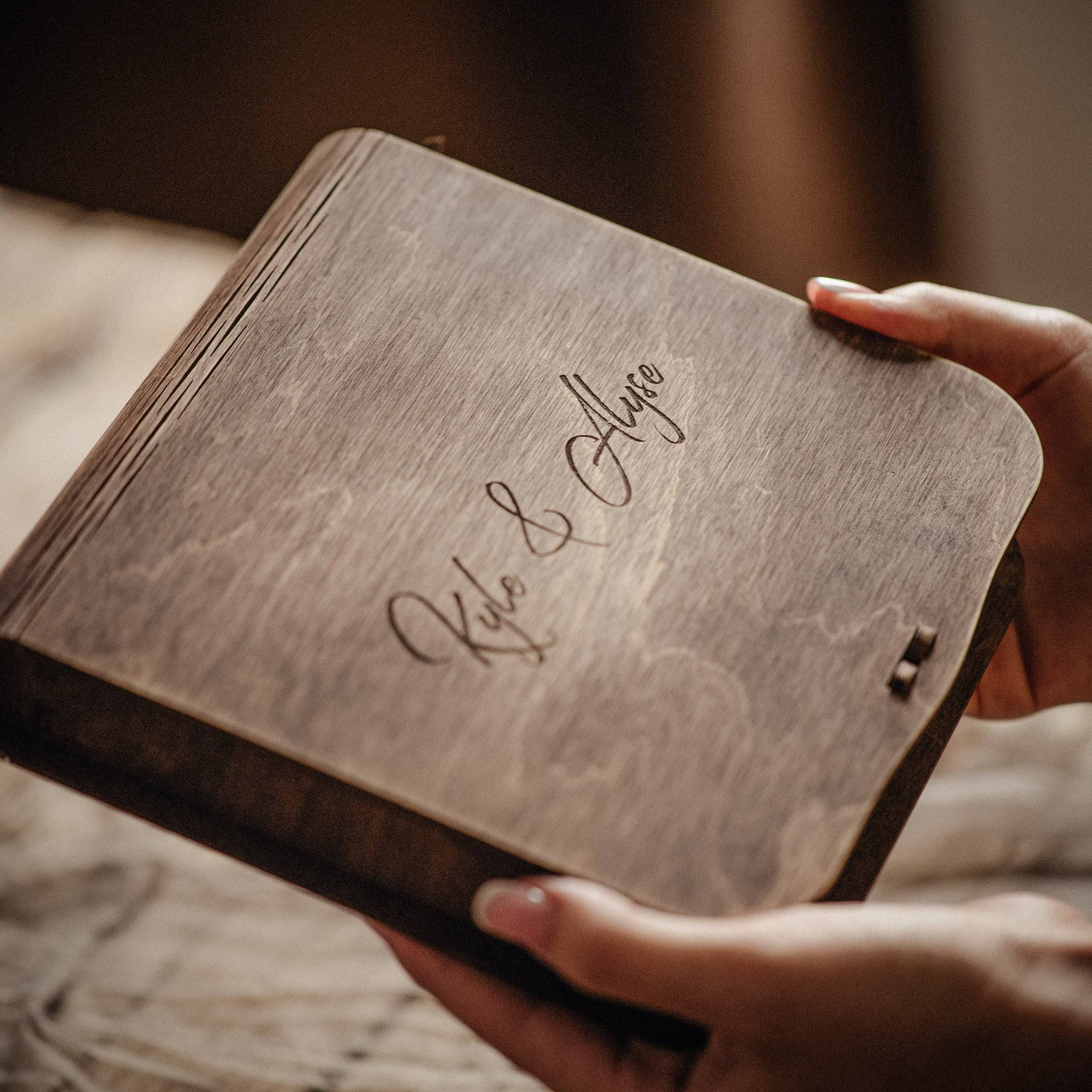 Vintage style wooden photo box with engraved names, closed box held in hands
