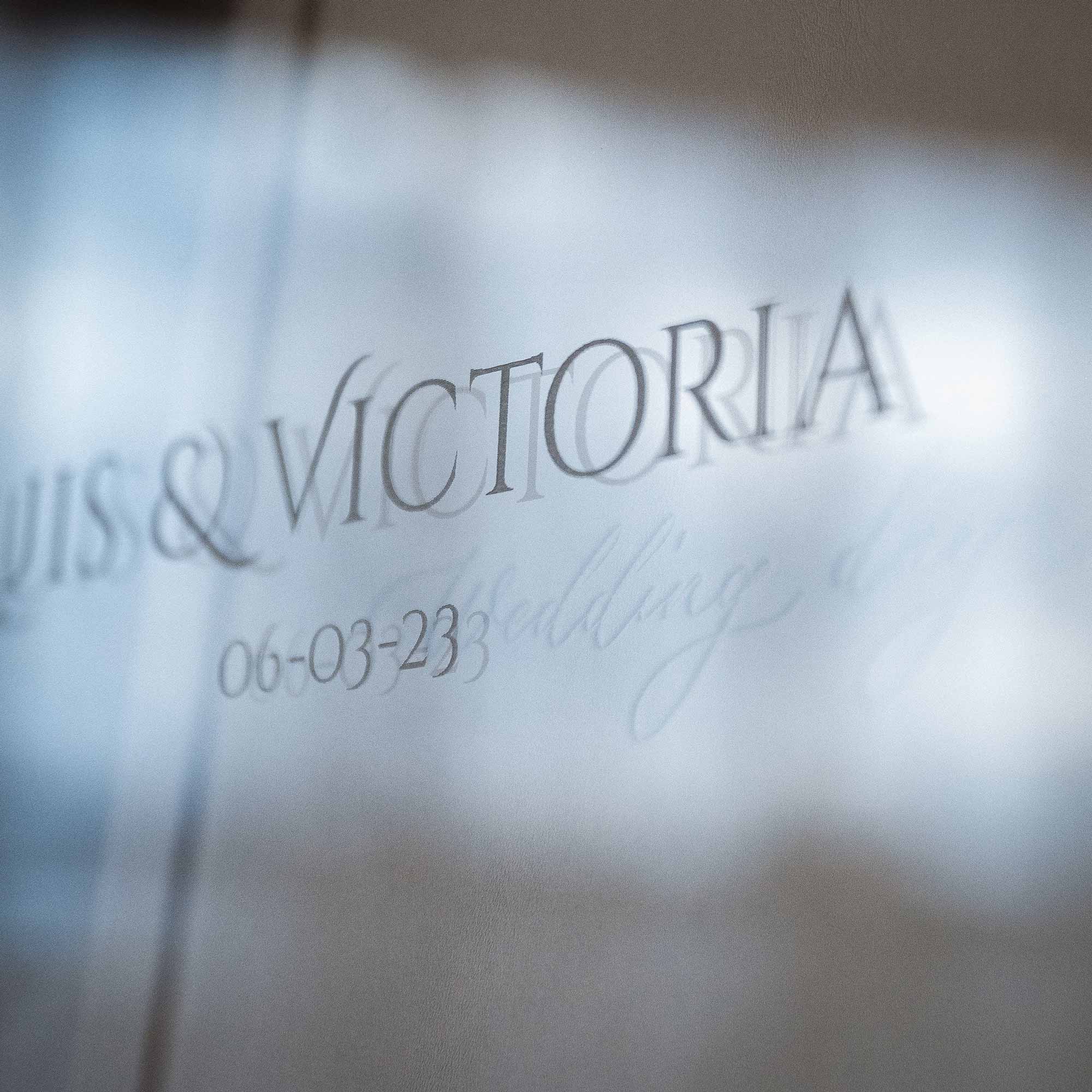 Close up of engraved couple names on acrylic lid of wooden wedding album box