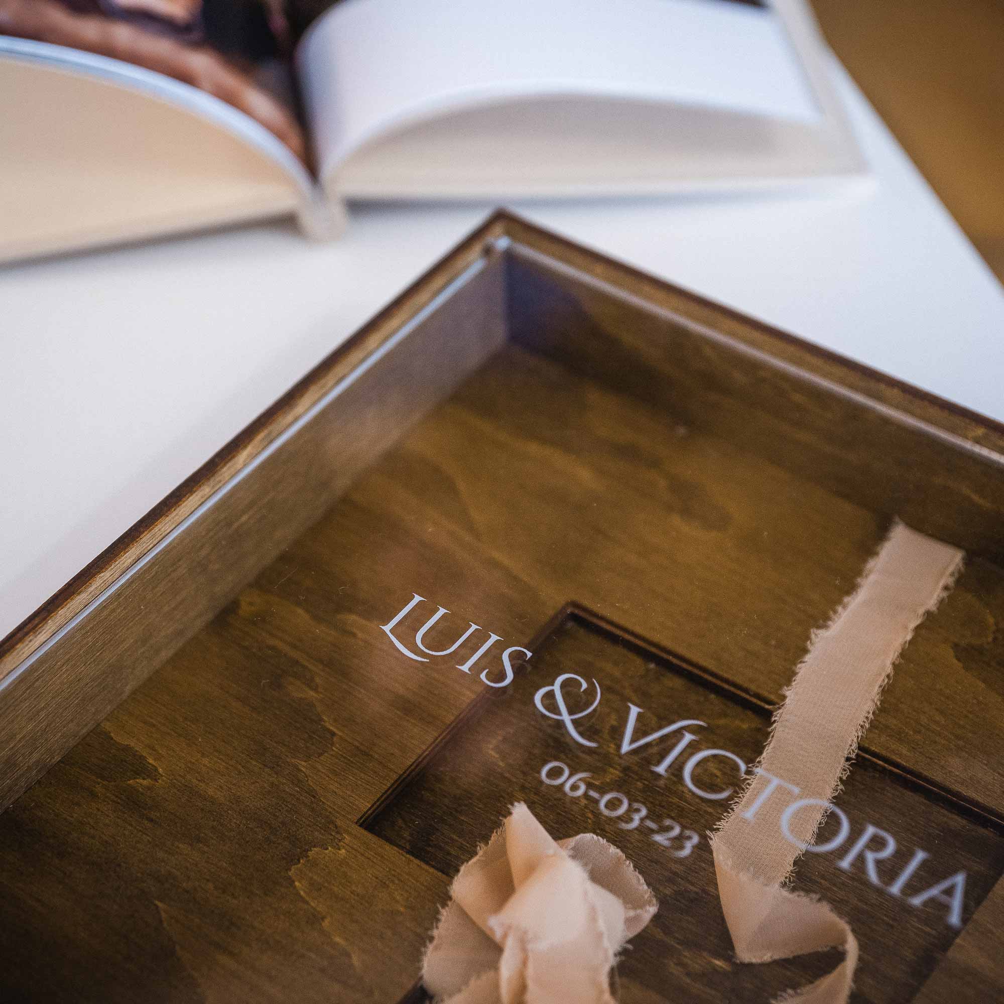 Walnut wooden album box with acrylic lid showing wedding album and ribbon